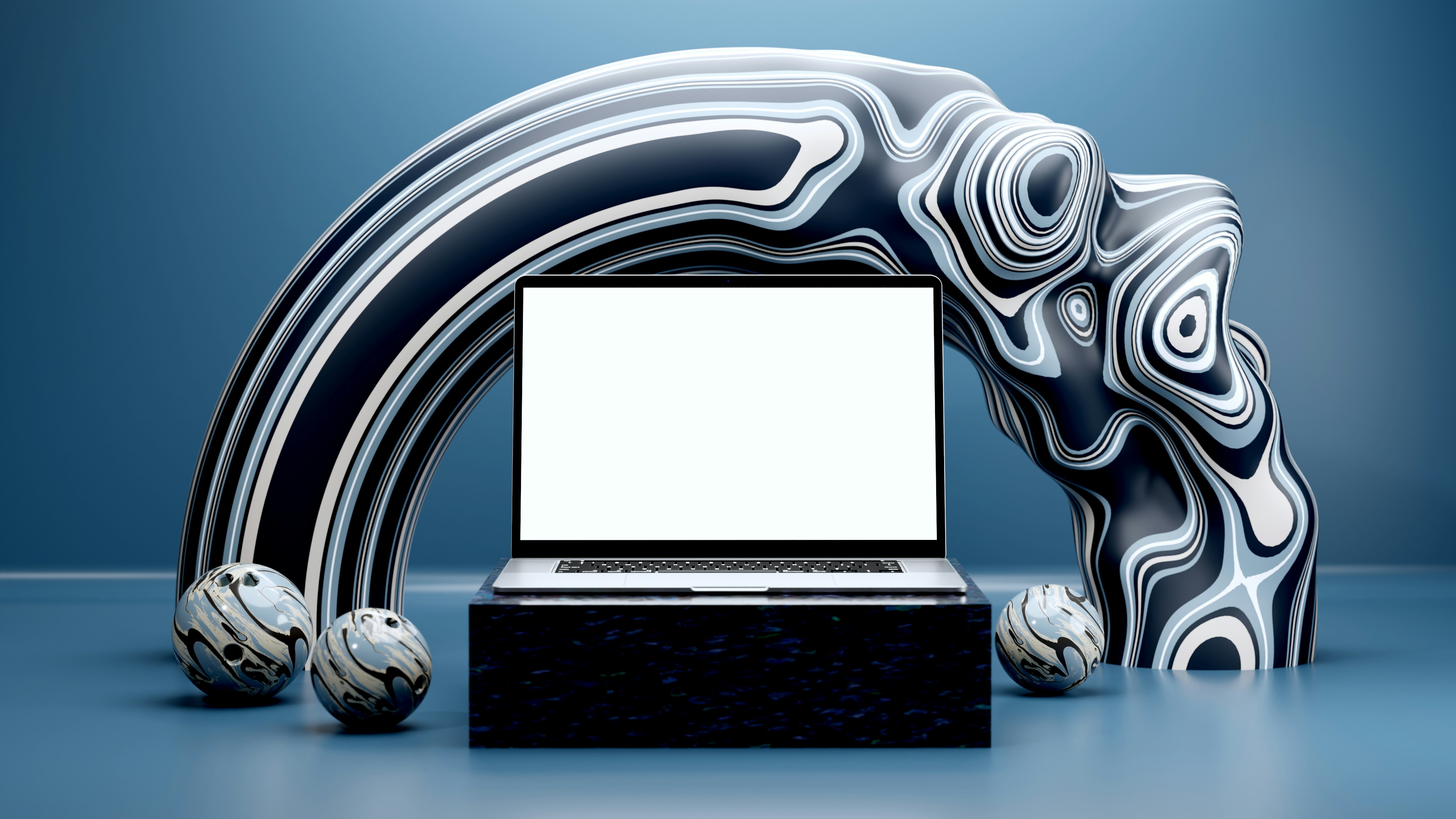 Laptop on pedestal with abstract sculptures and spherical art