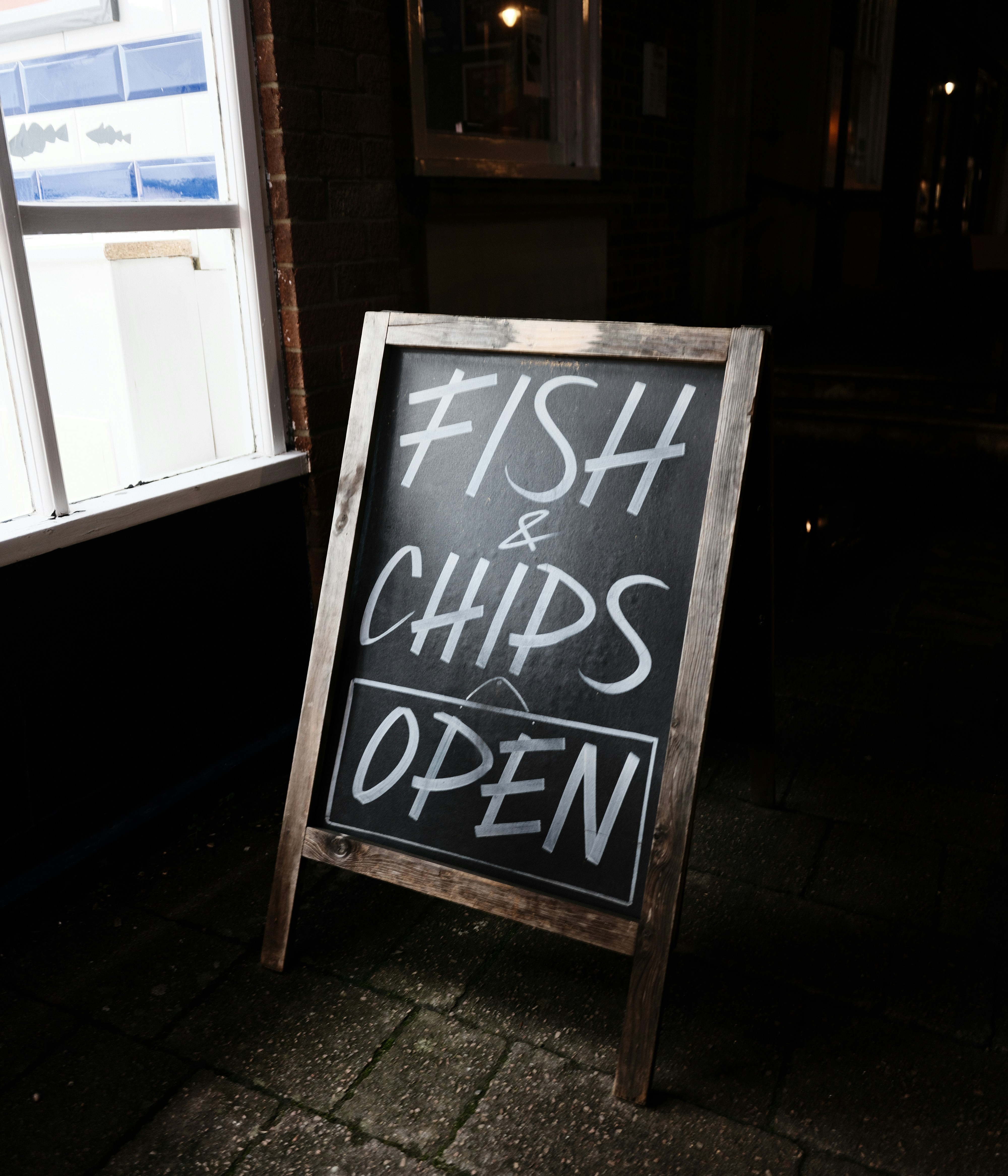 A chalkboard sign reads "fish & chips open".