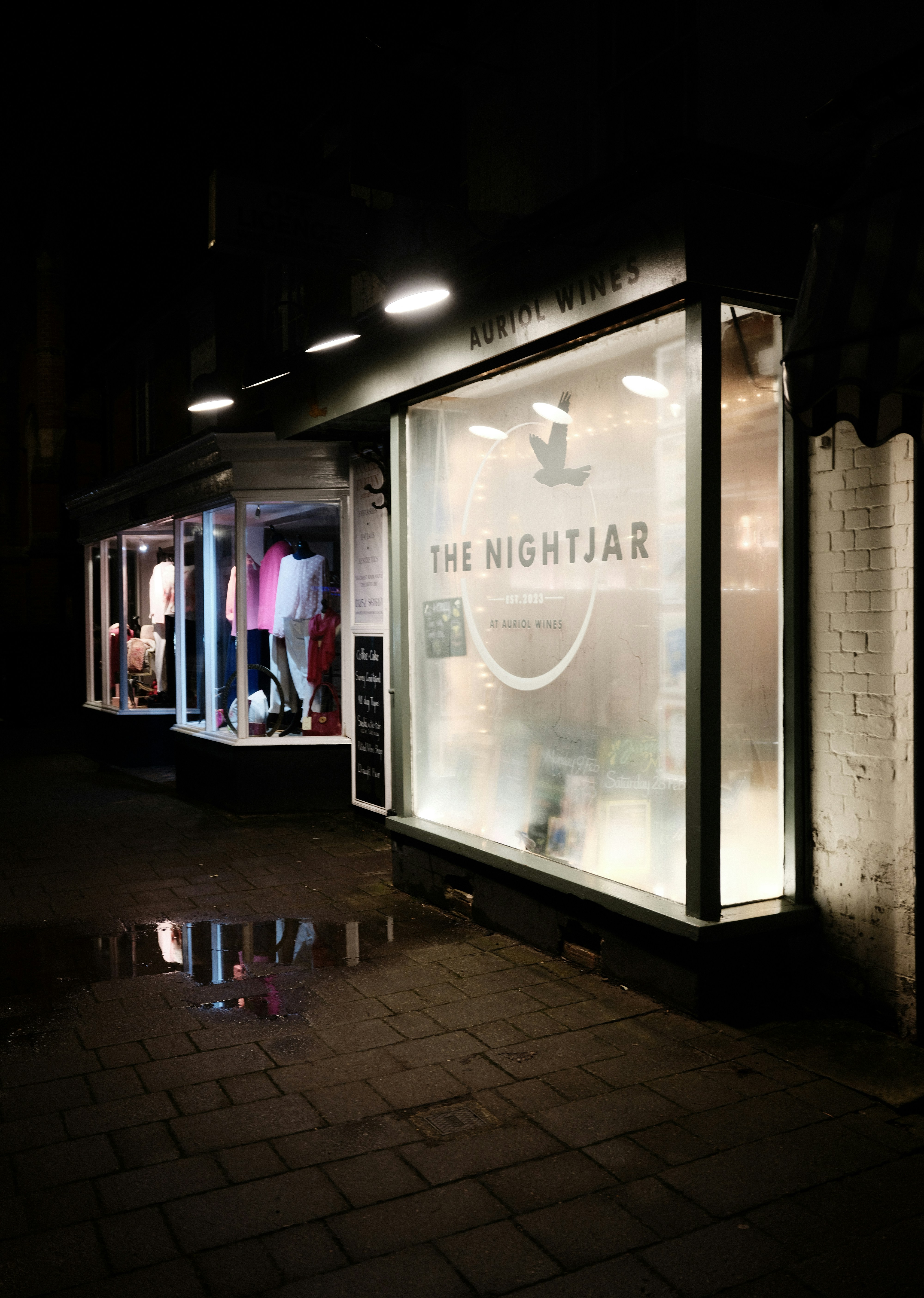 A storefront called the nightjar at night.