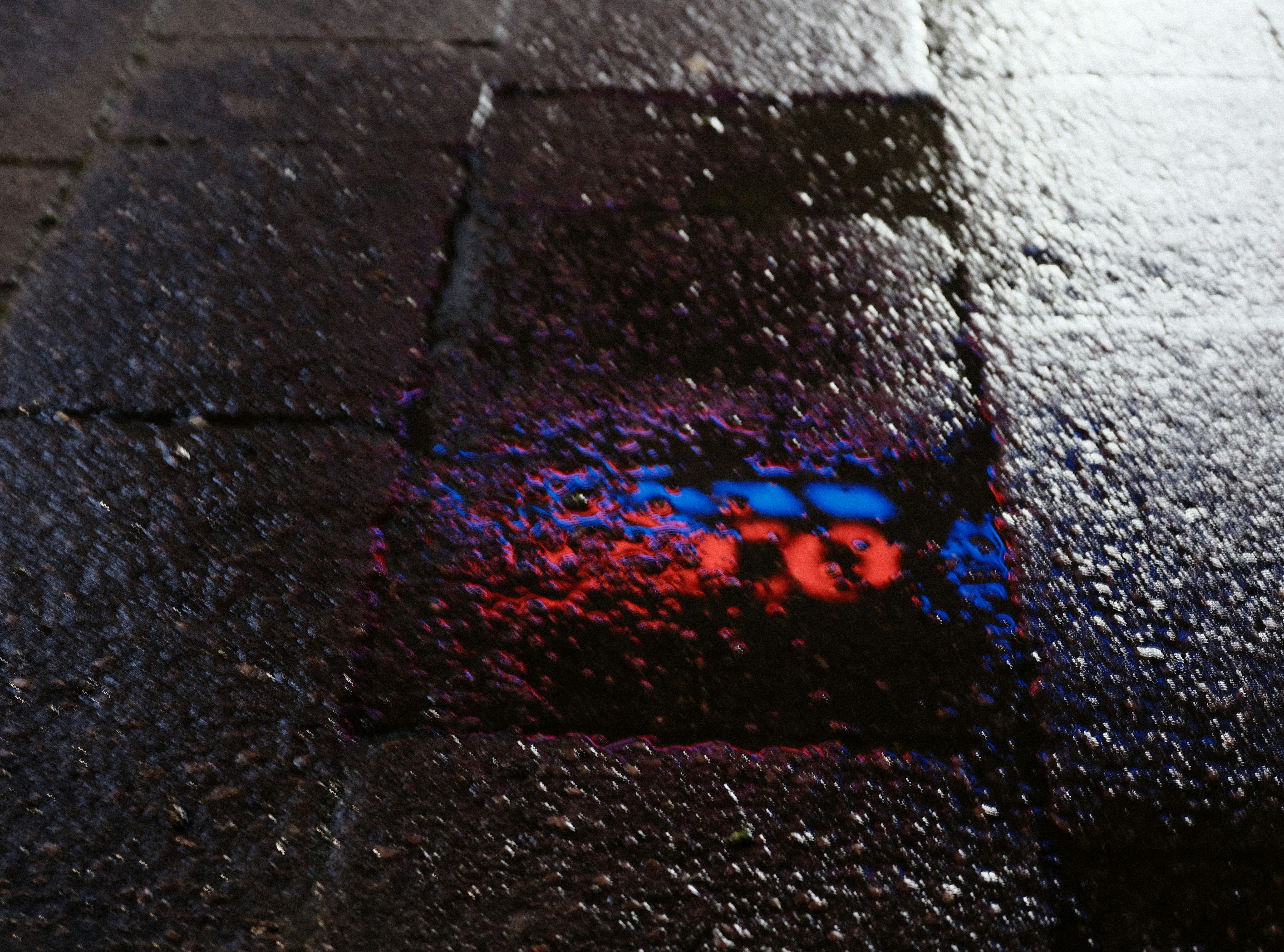 Colorful reflection on wet asphalt at night