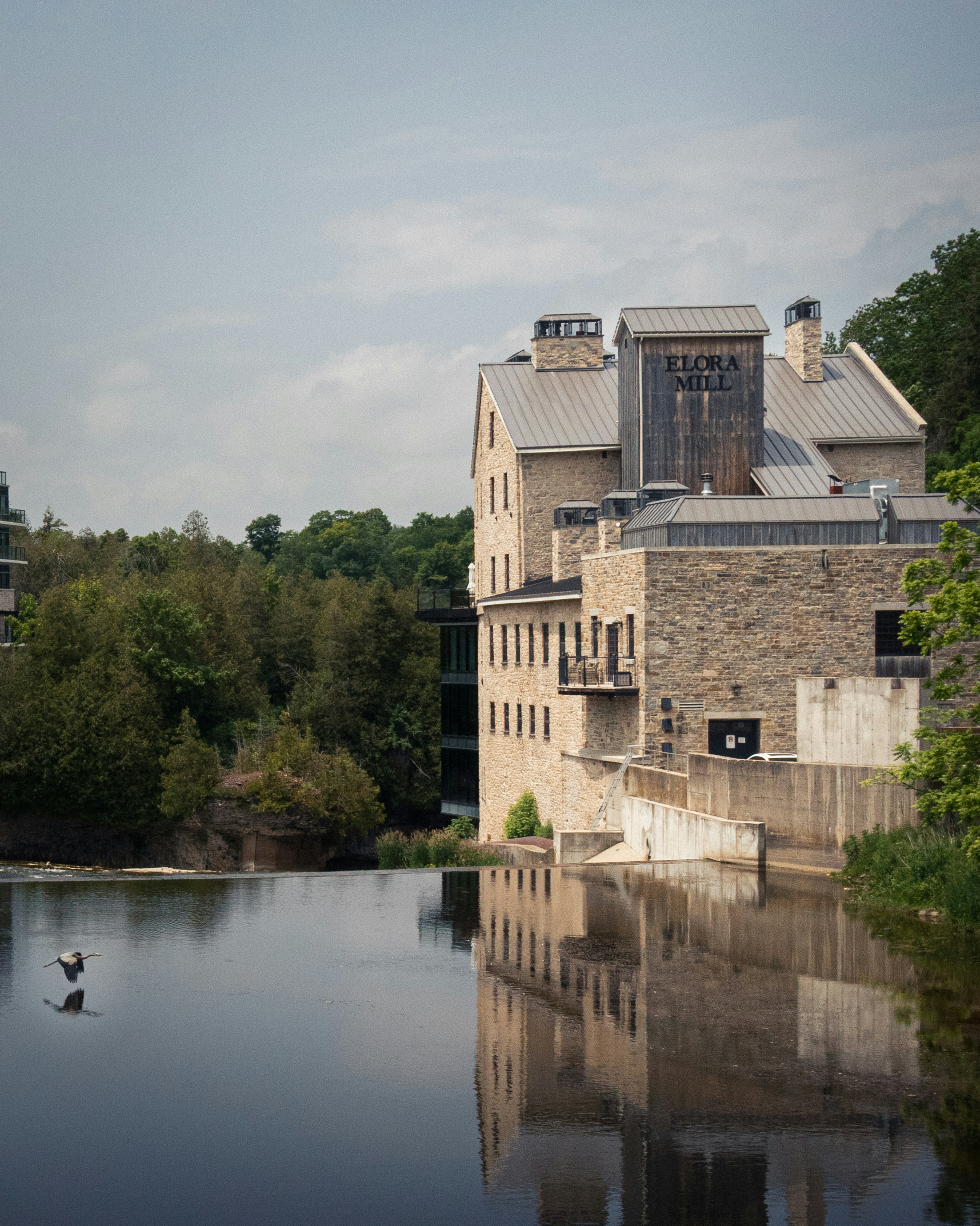 Stone mill building reflected in calm water