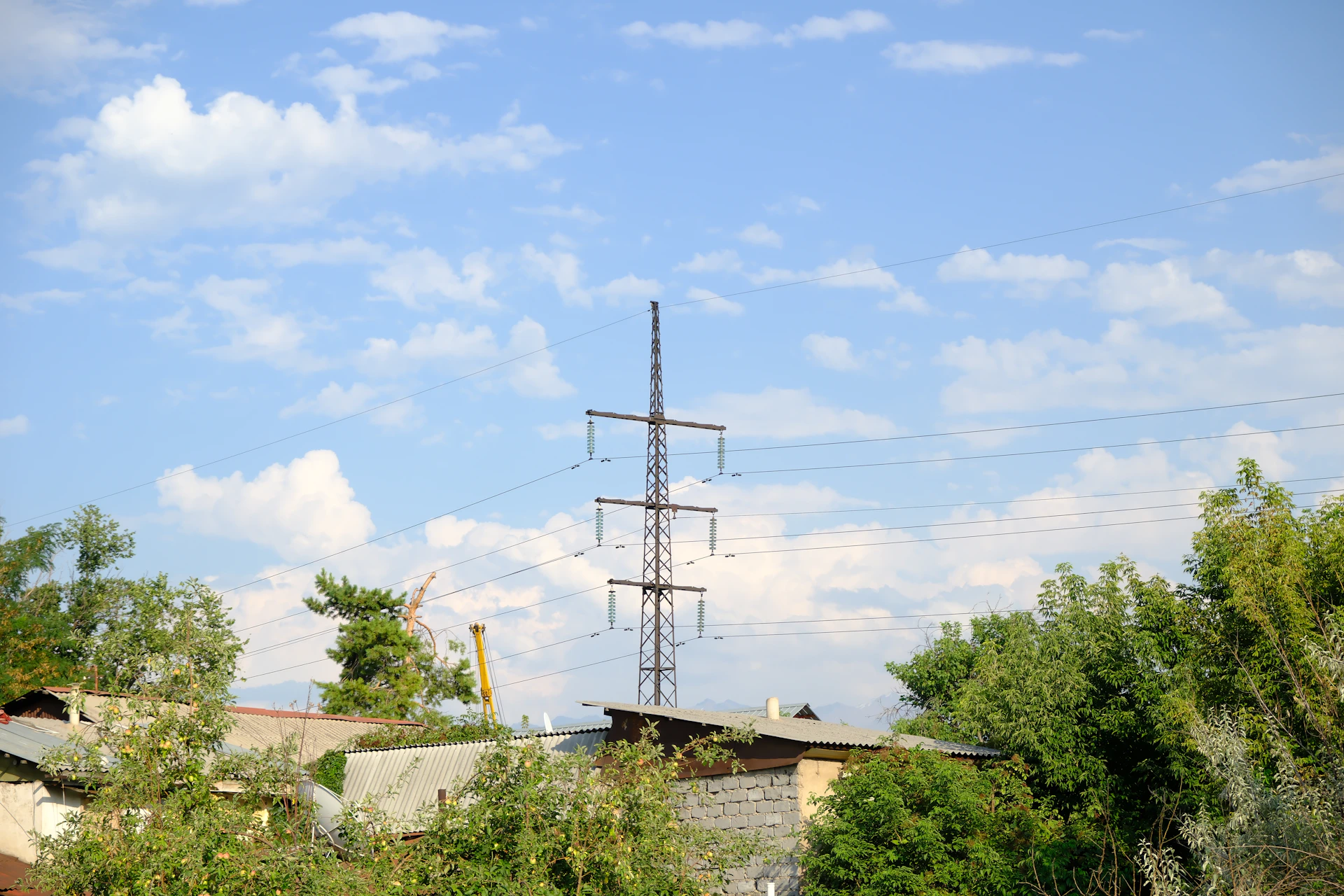 A tall power line tower against a blue sky.
