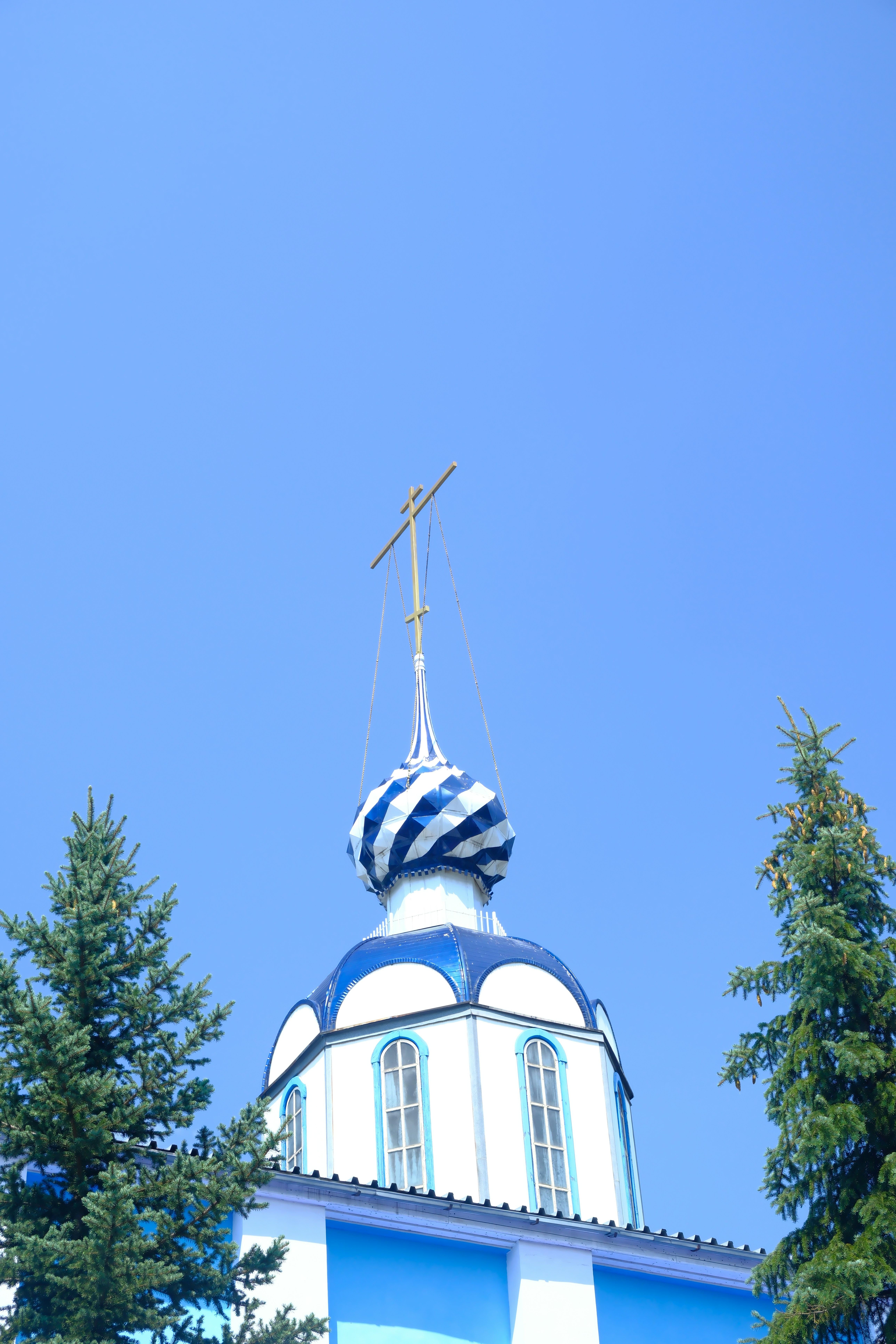 Kubah gereja biru dan putih dengan salib.
