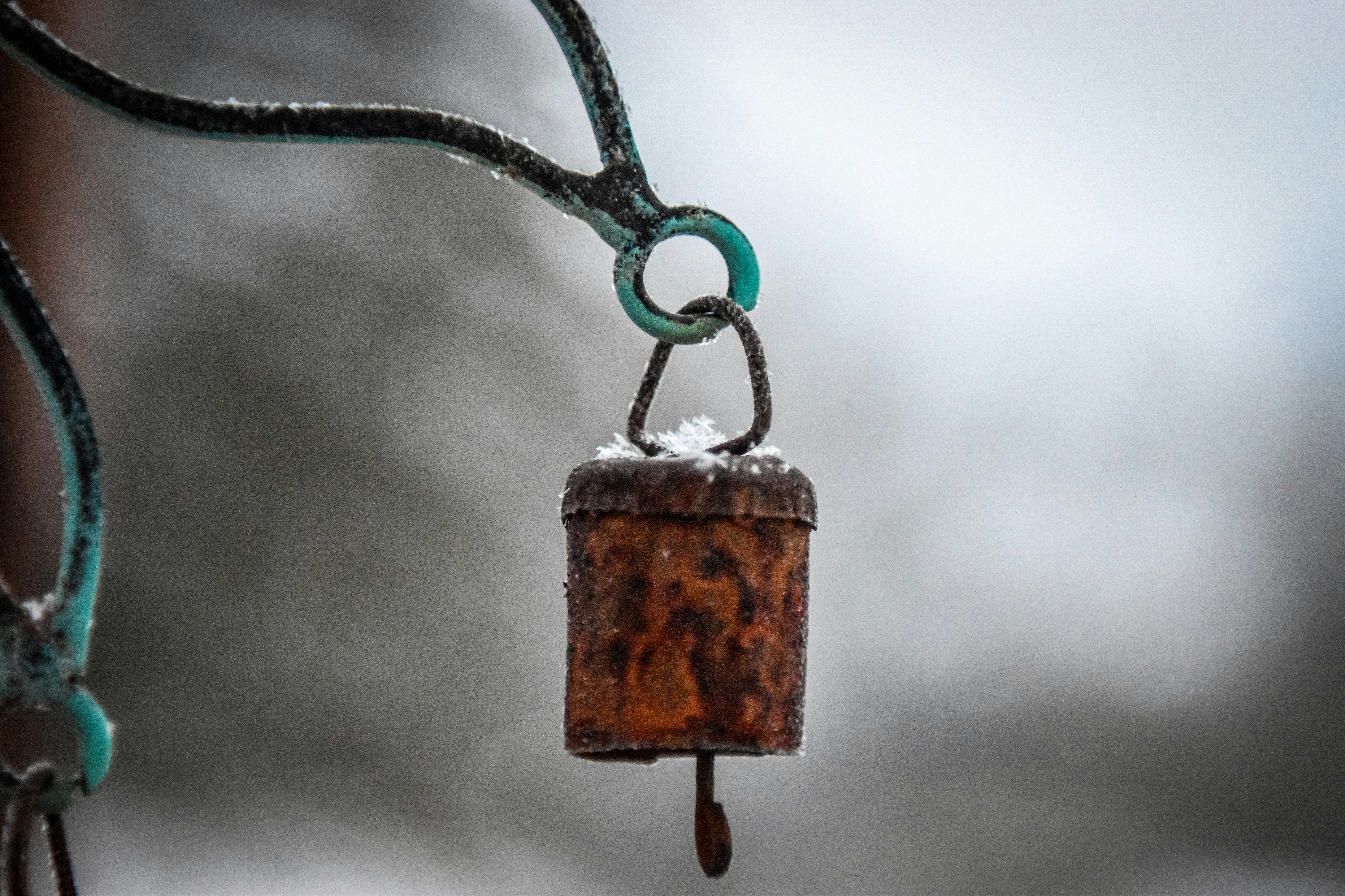 A rusty wind chime hanging outdoors in winter