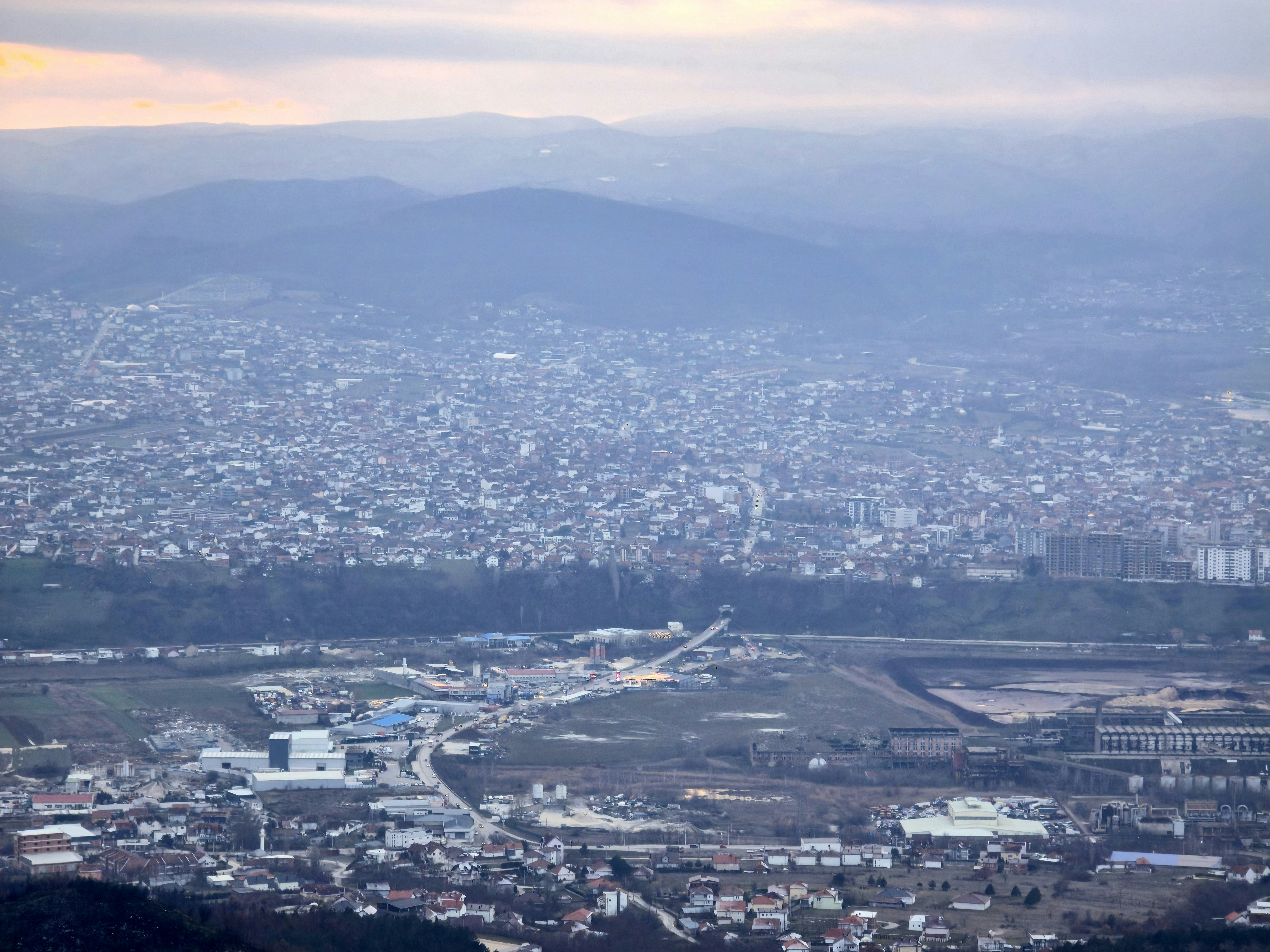 A sprawling city nestled in a valley with mountains.