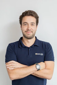 Man wearing a dark blue polo shirt with arms crossed