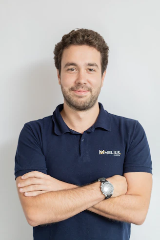 Man wearing a dark blue polo shirt with arms crossed