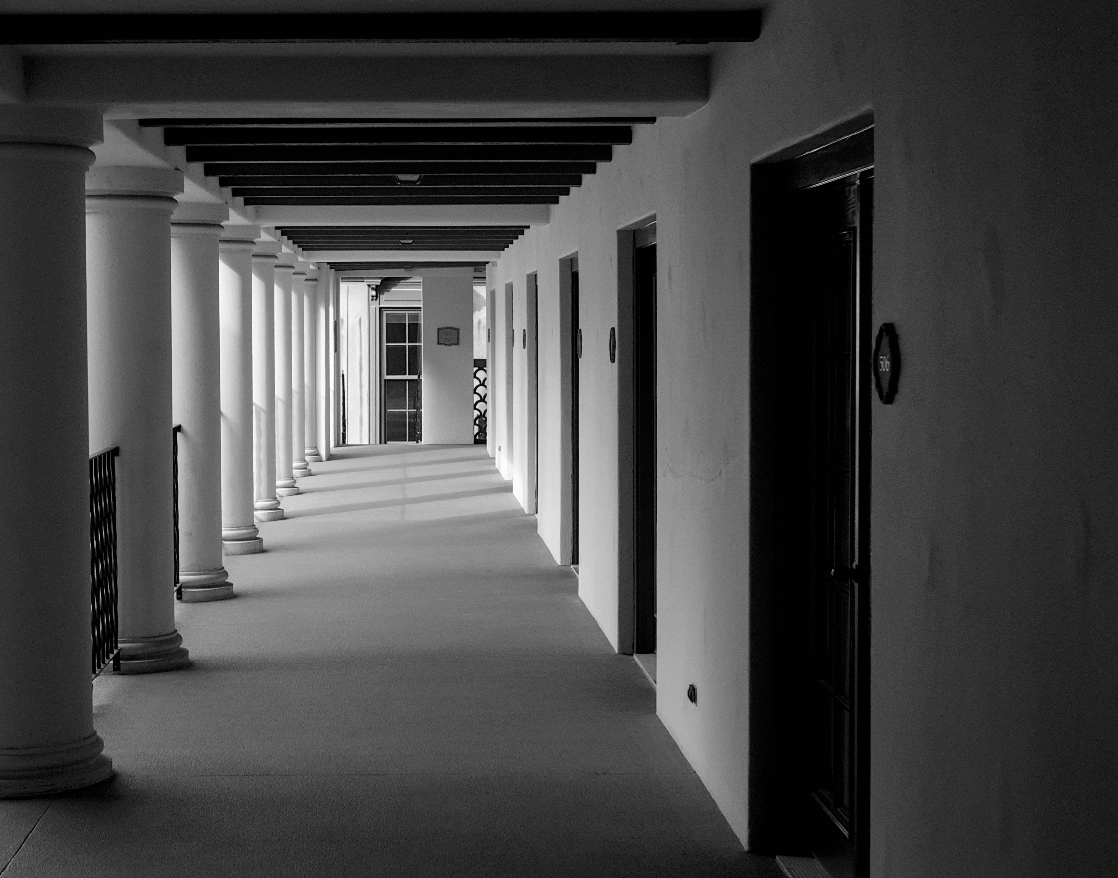 Un pasillo largo y vacío con columnas y puertas
