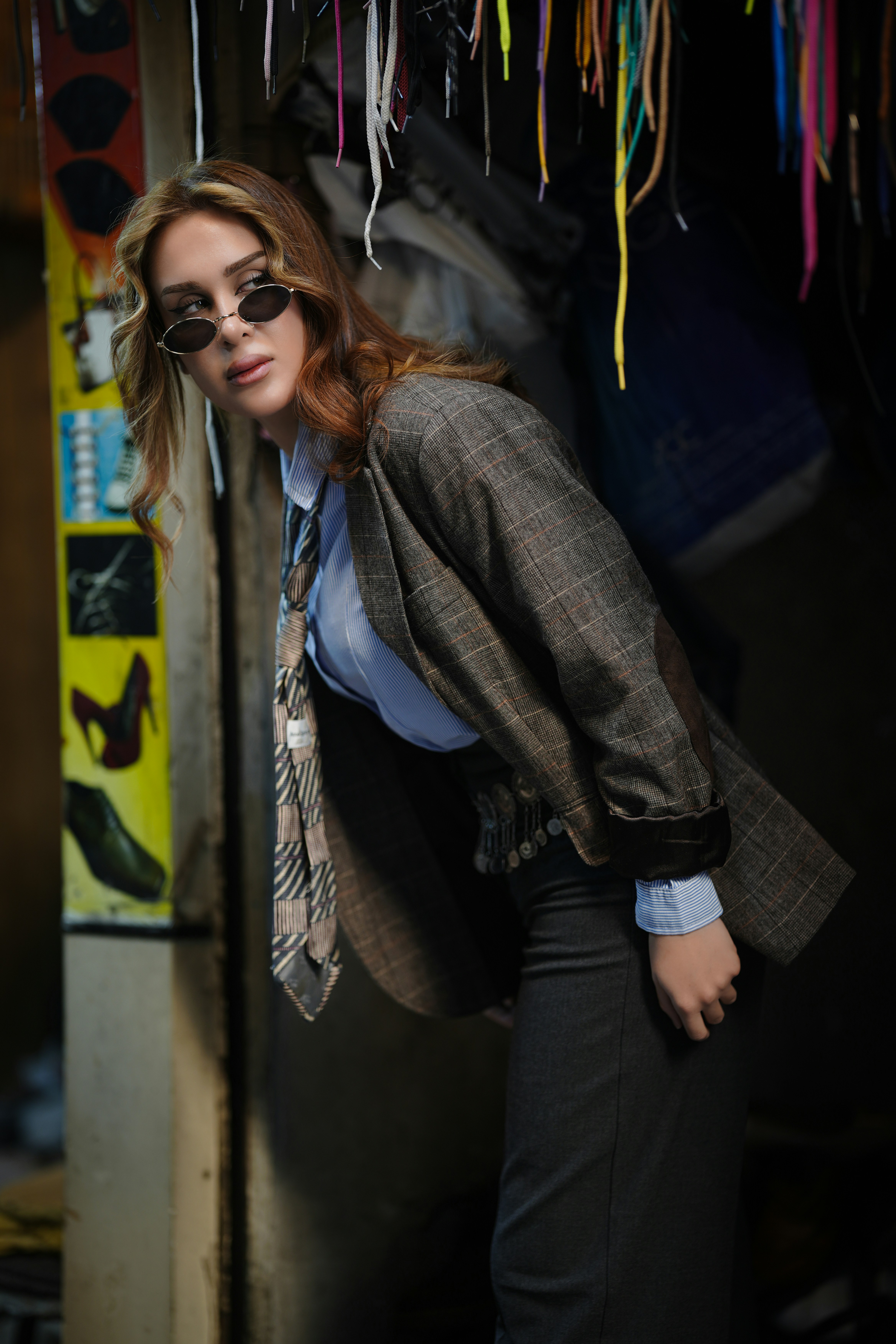 Woman in sunglasses and blazer leans forward