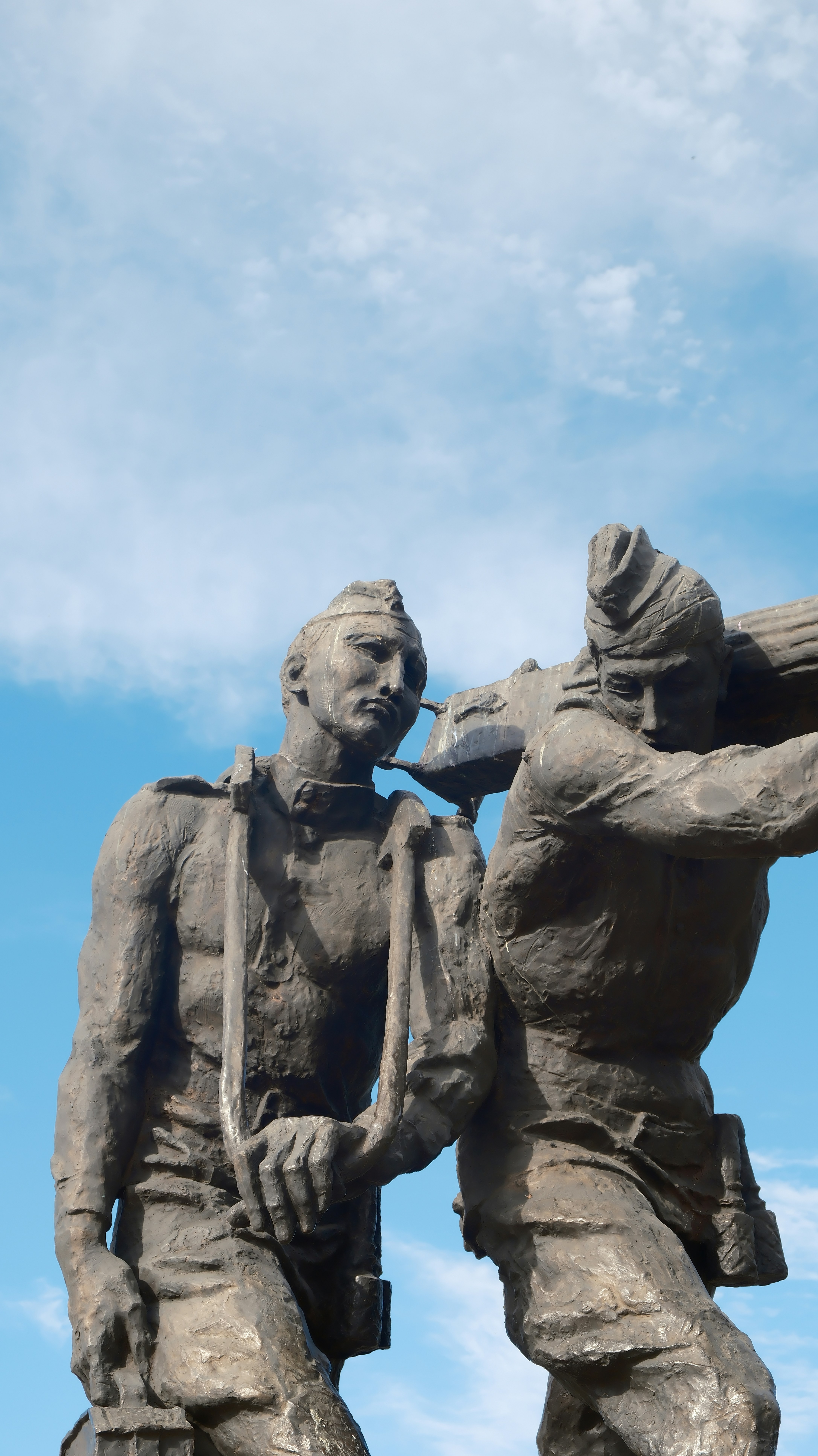 二人の石兵が大きな丸太を一緒に運ぶ様子。