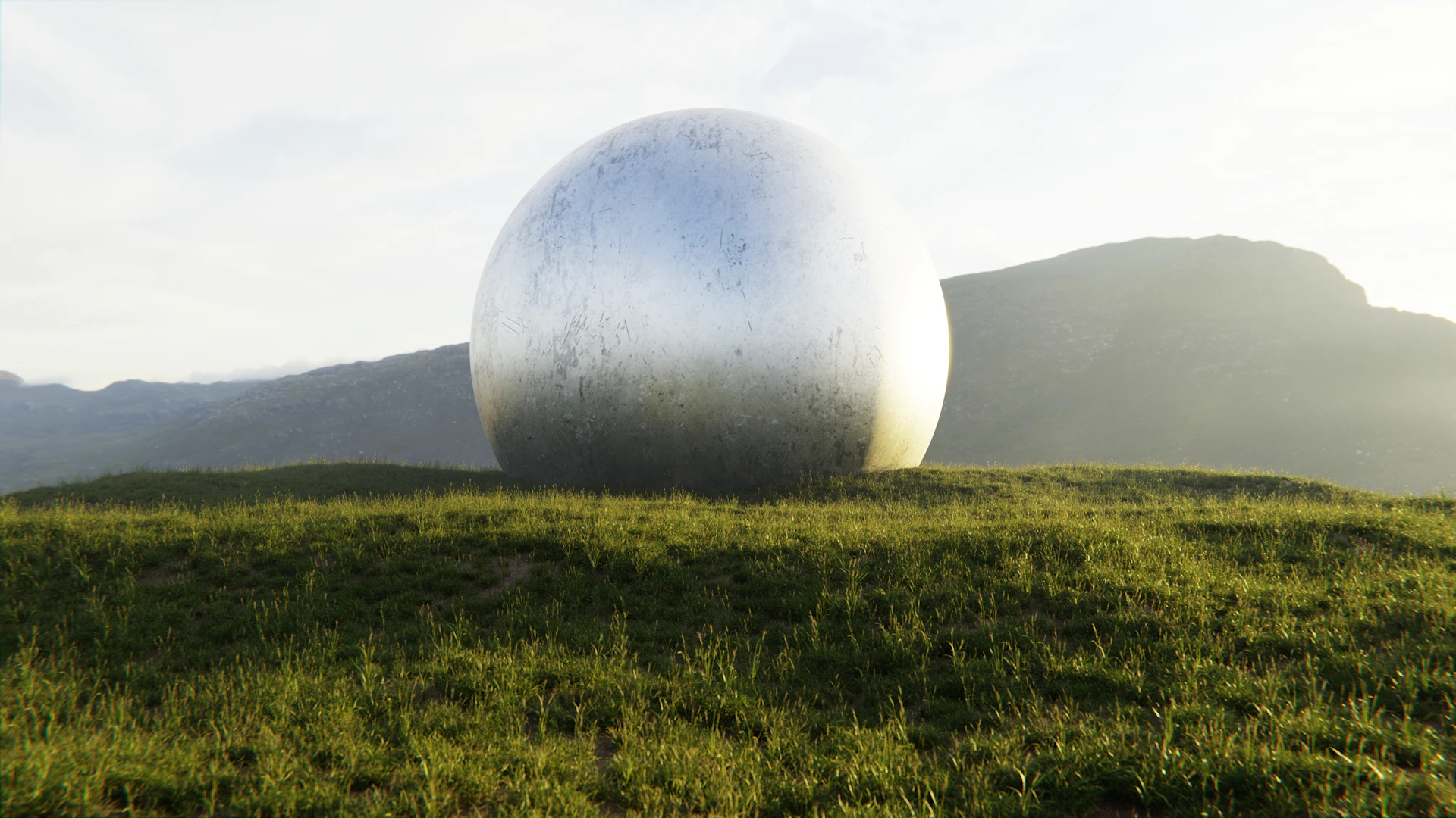 A large metallic sphere rests on a grassy hill.