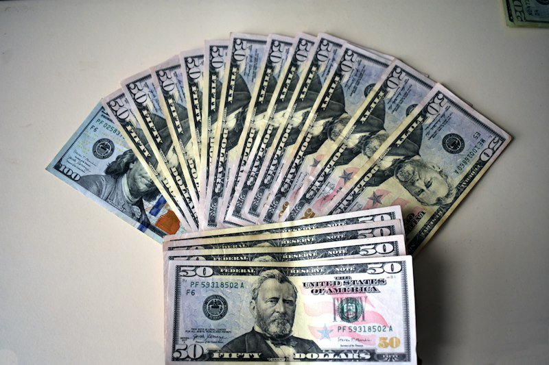 Fan of fifty dollar bills on a white surface