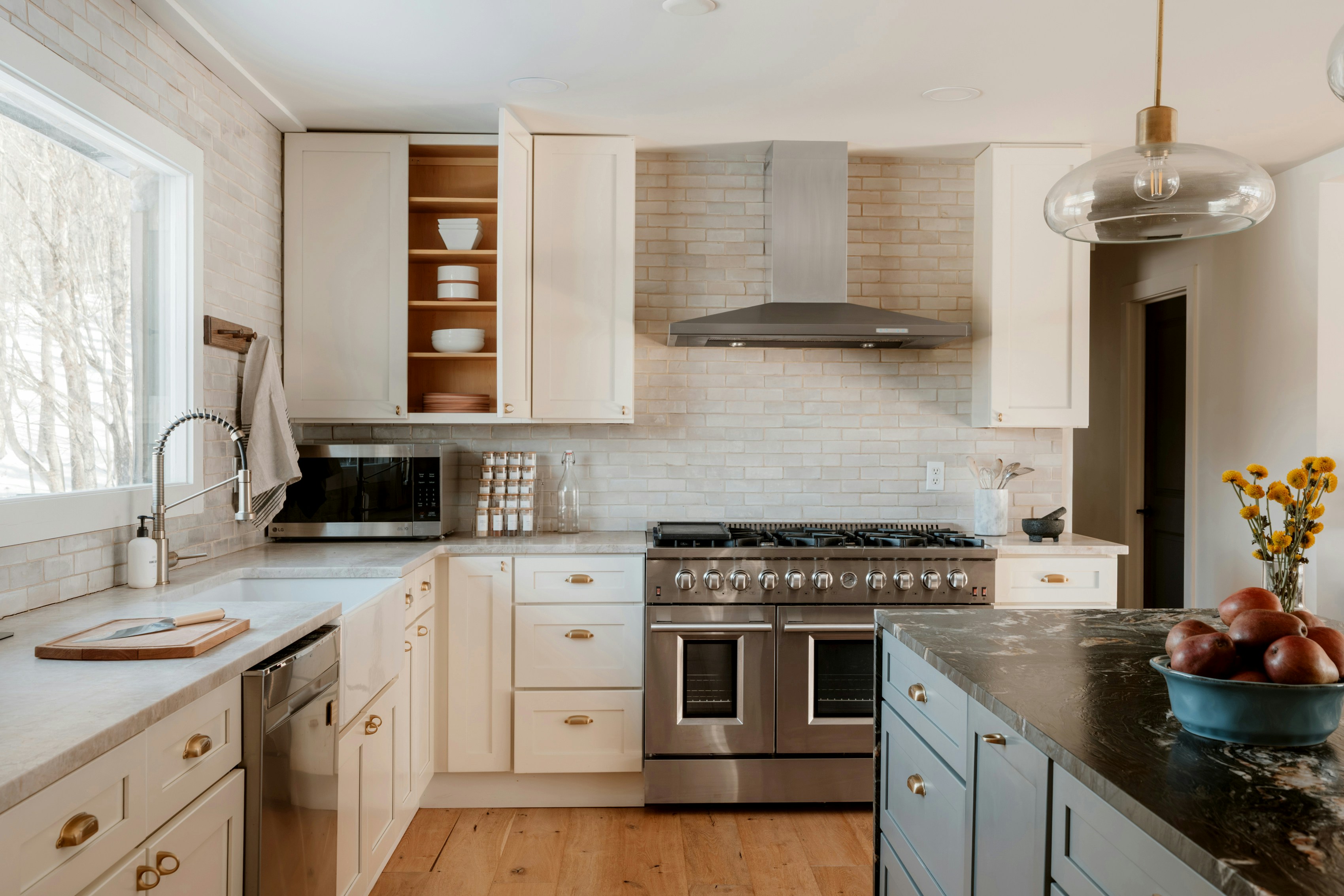 Modern kitchen with stainless steel appliances and white cabinets.
