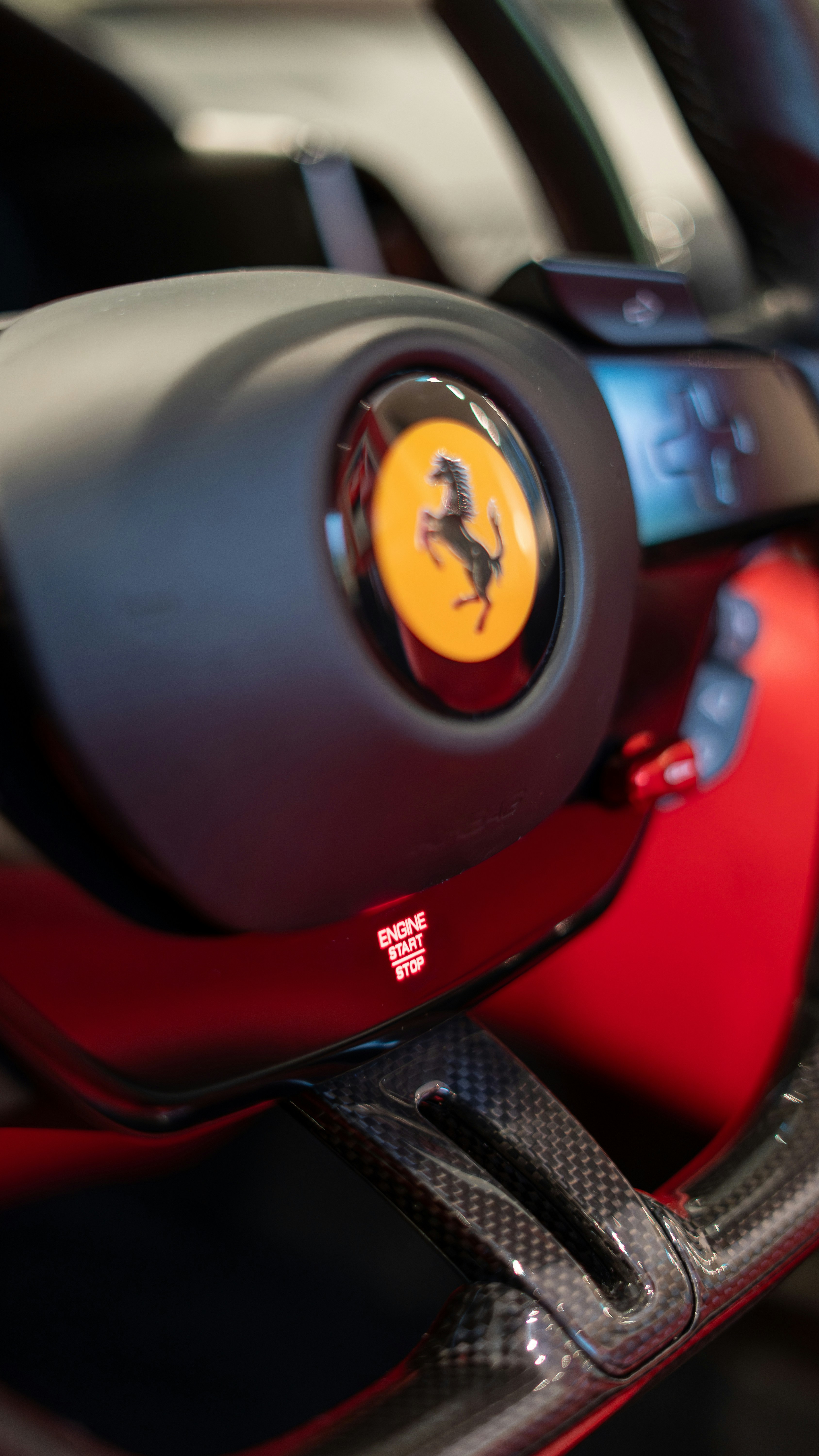 Close-up of a ferrari steering wheel with prancing horse logo.
