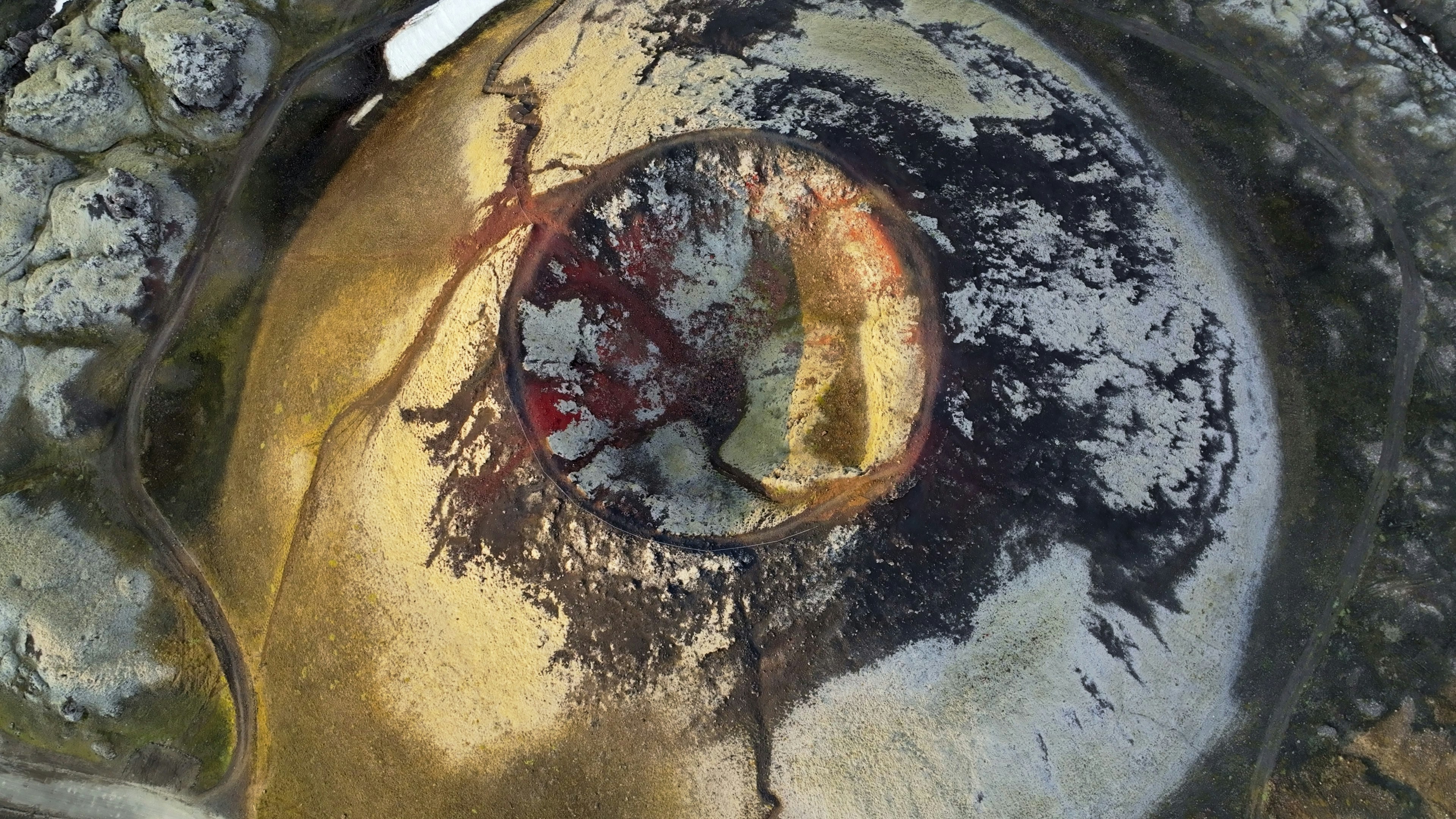 Aerial view of a colorful volcanic crater with geothermal activity