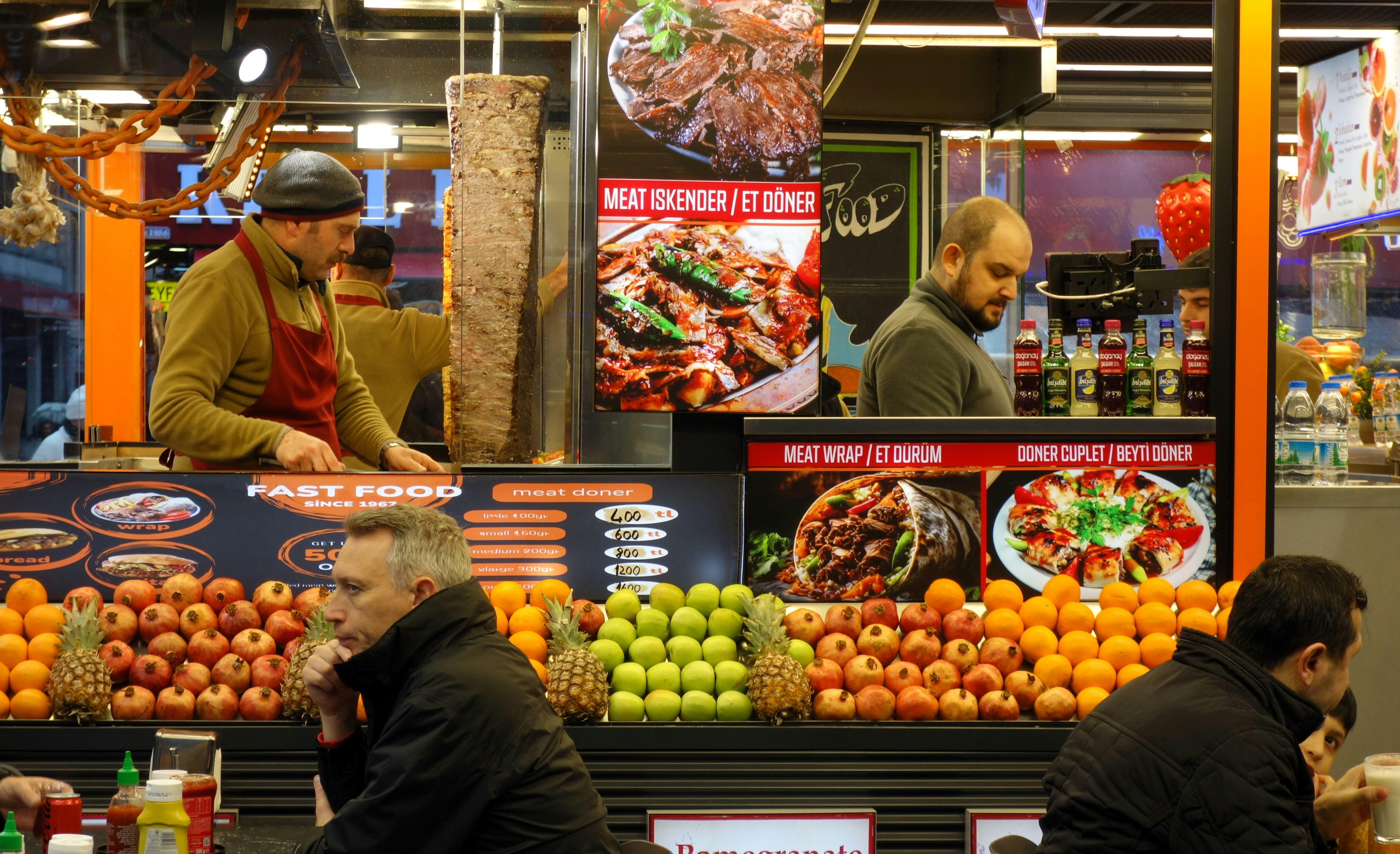 Street food vendors prepare meals at a busy market stall.
