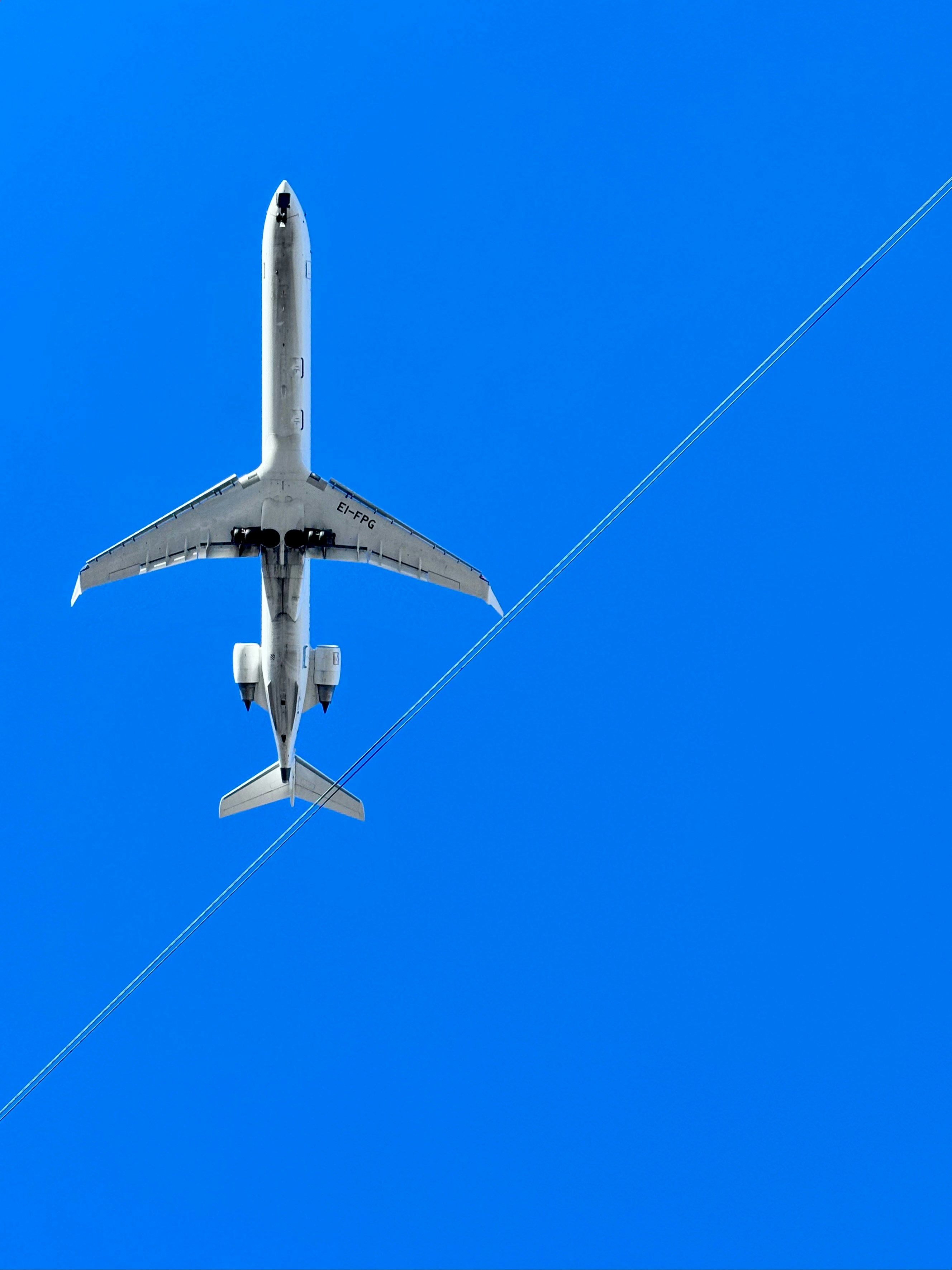 Airplane flying high in the bright blue sky.