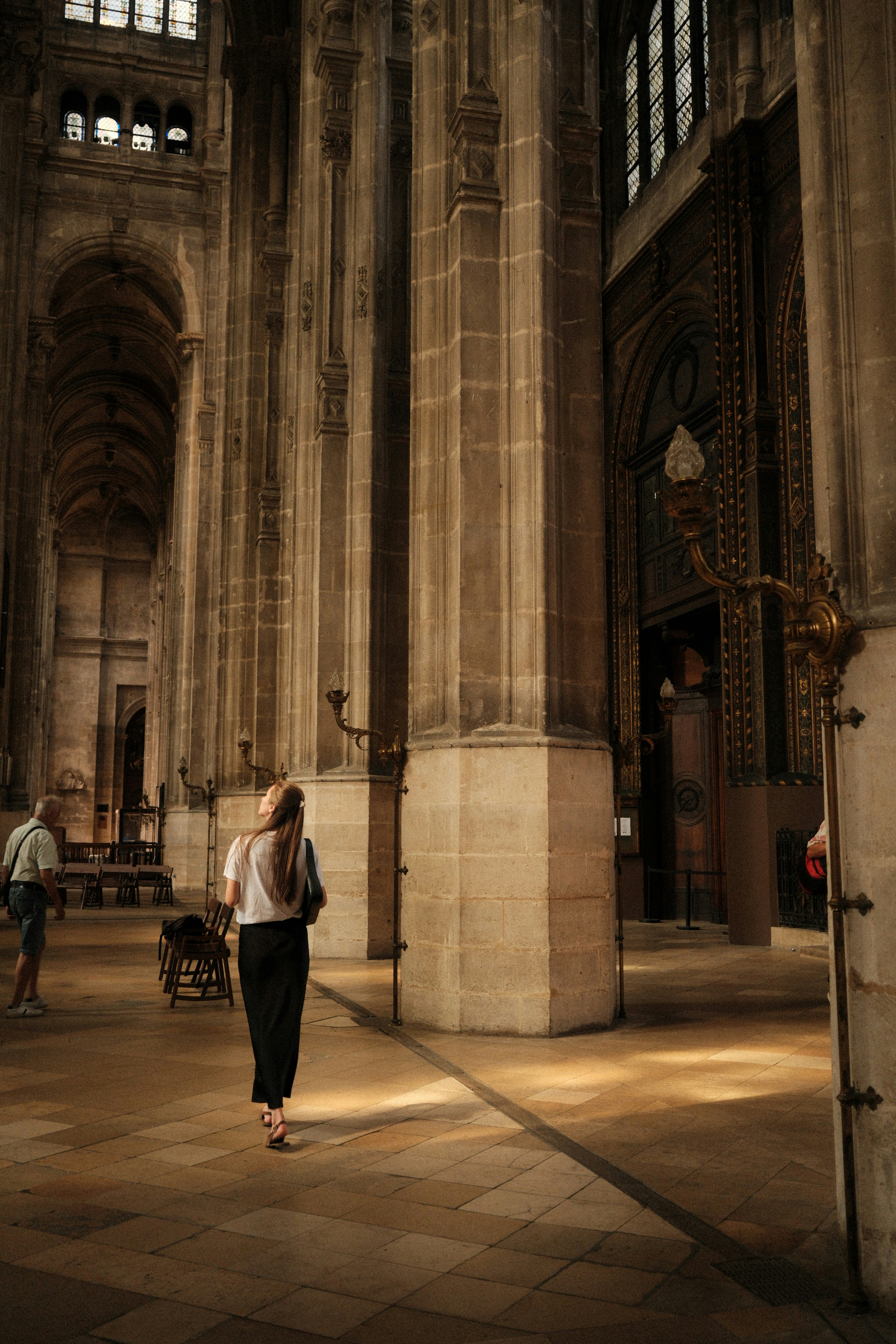 Femme marchant à travers un grand intérieur de cathédrale