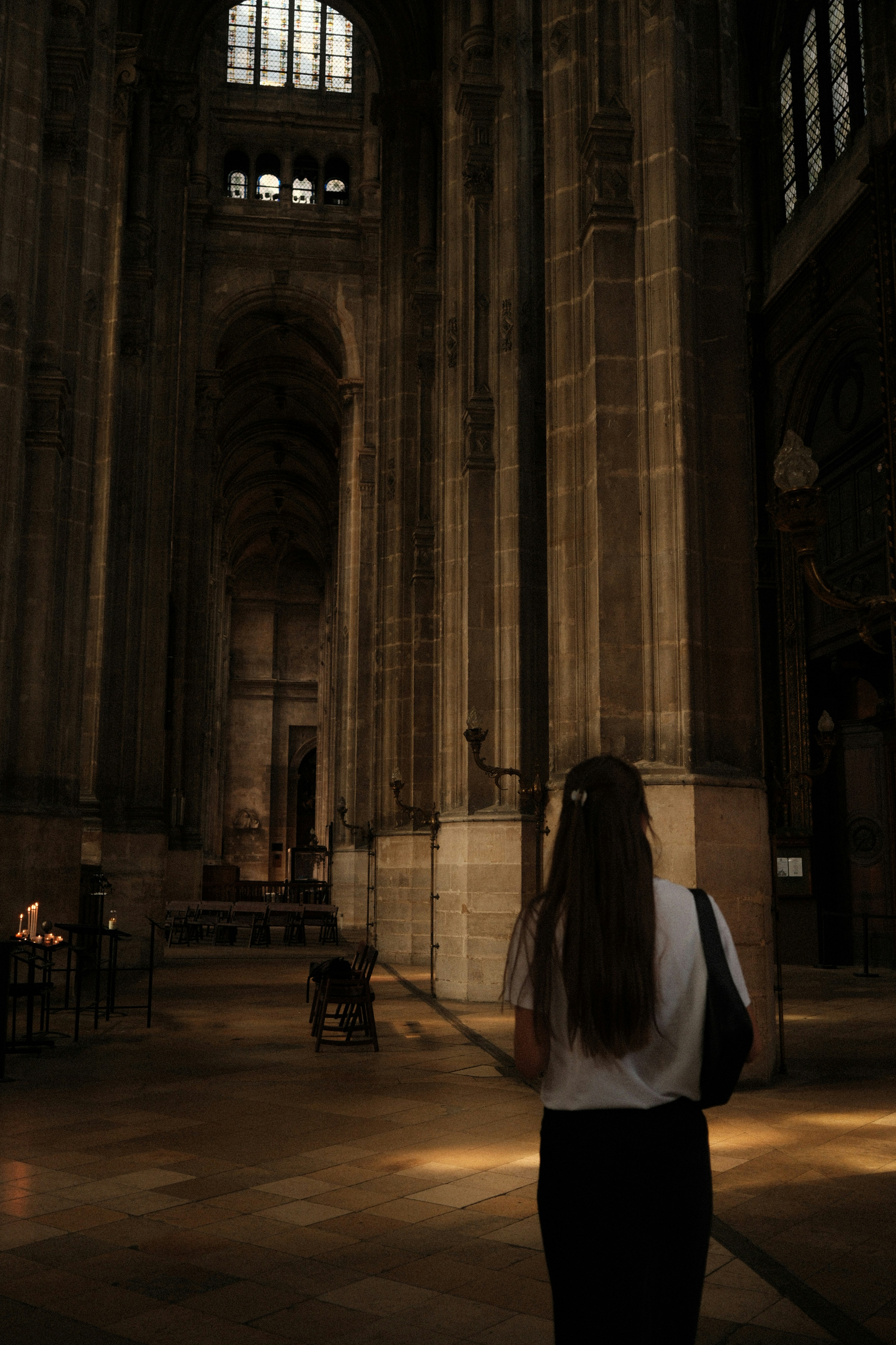 Femme marchant dans un grand intérieur de cathédrale.