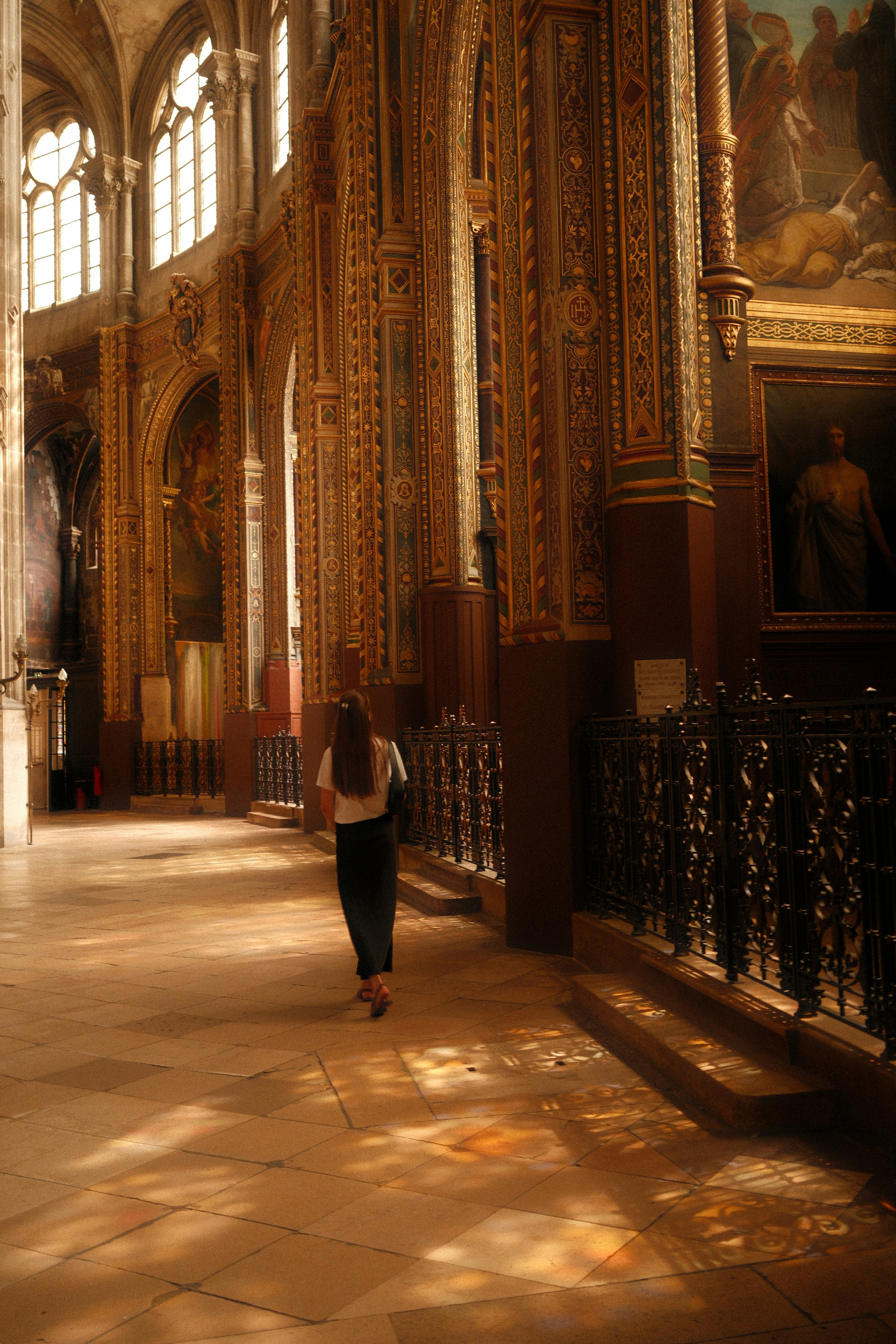 Une femme marchant dans l’intérieur orné de l’église sous le soleil.