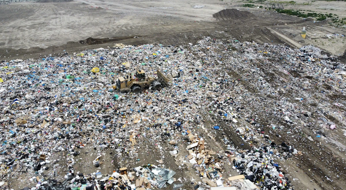Buldoser memadatkan sampah di tempat pembuangan akhir