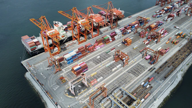 Busy shipping port with cranes and cargo containers.