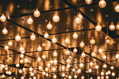 Many hanging light bulbs illuminated with warm light.