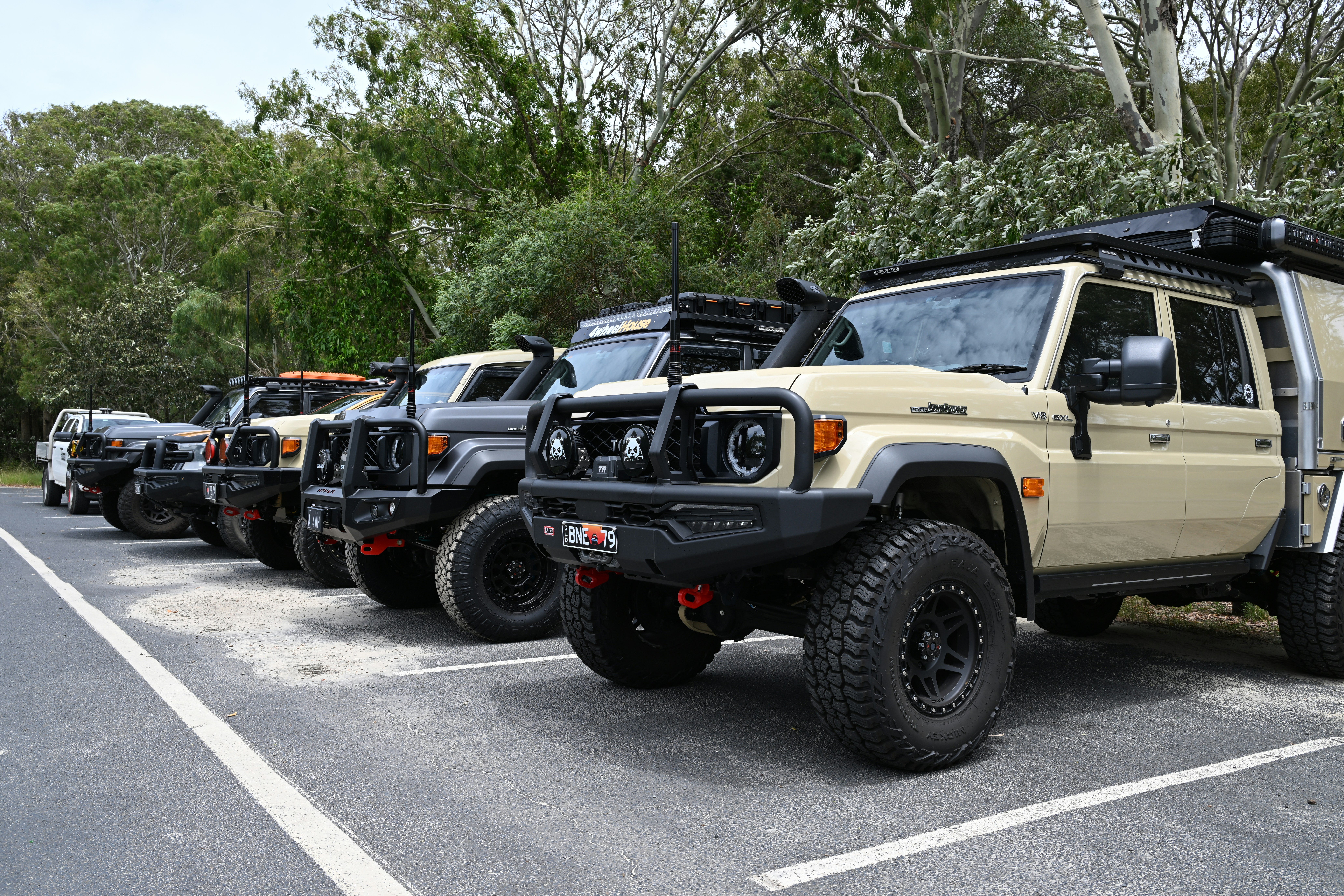 Several off-road vehicles parked in a row outdoors.