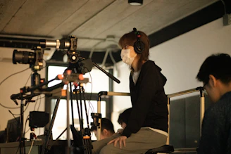 Filmmaker wearing headphones and mask with camera equipment