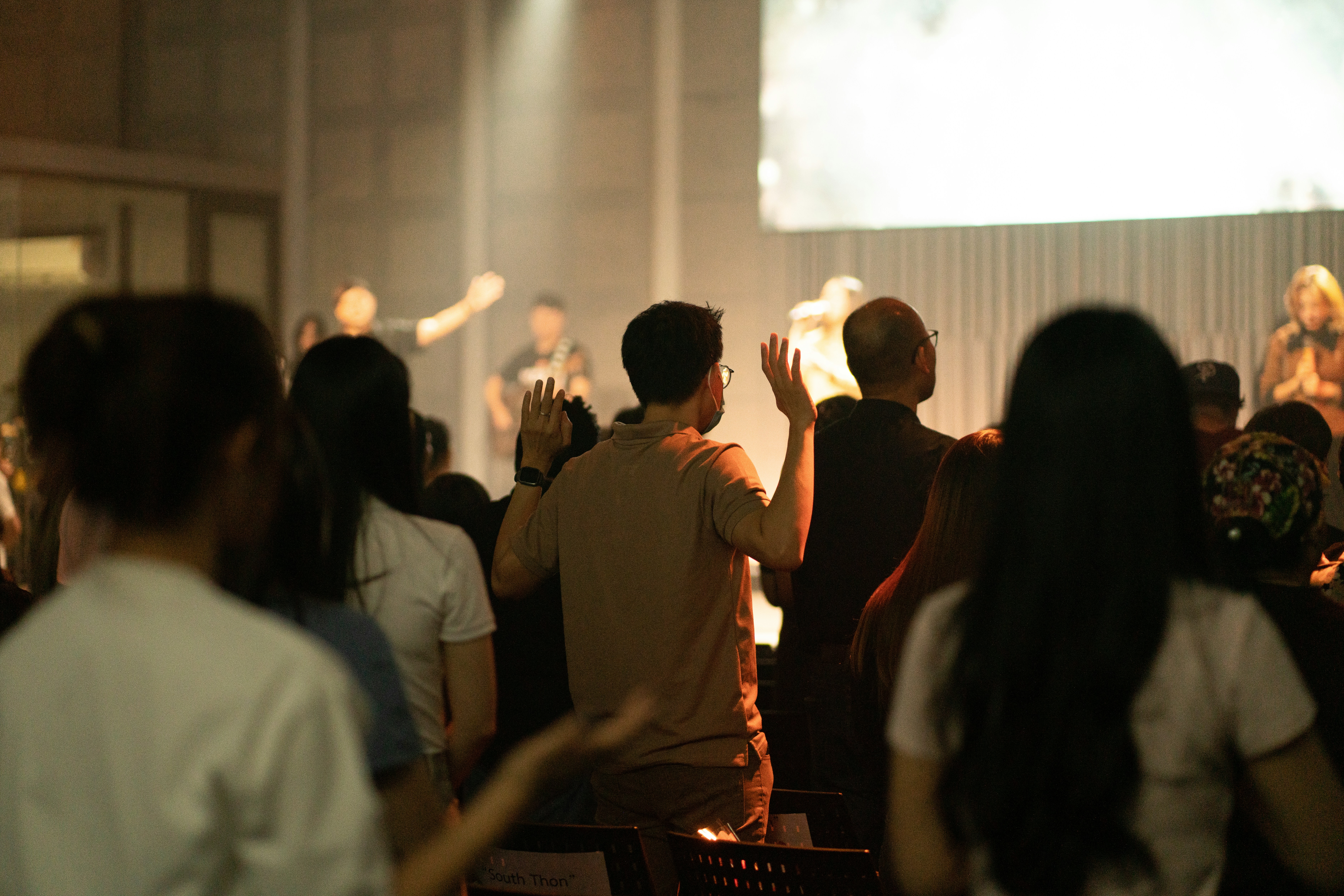 People raising hands in a worship service