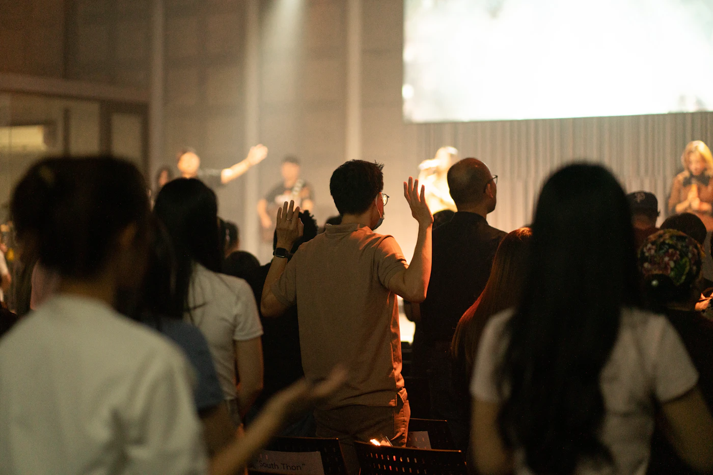 People worshipping in warm light