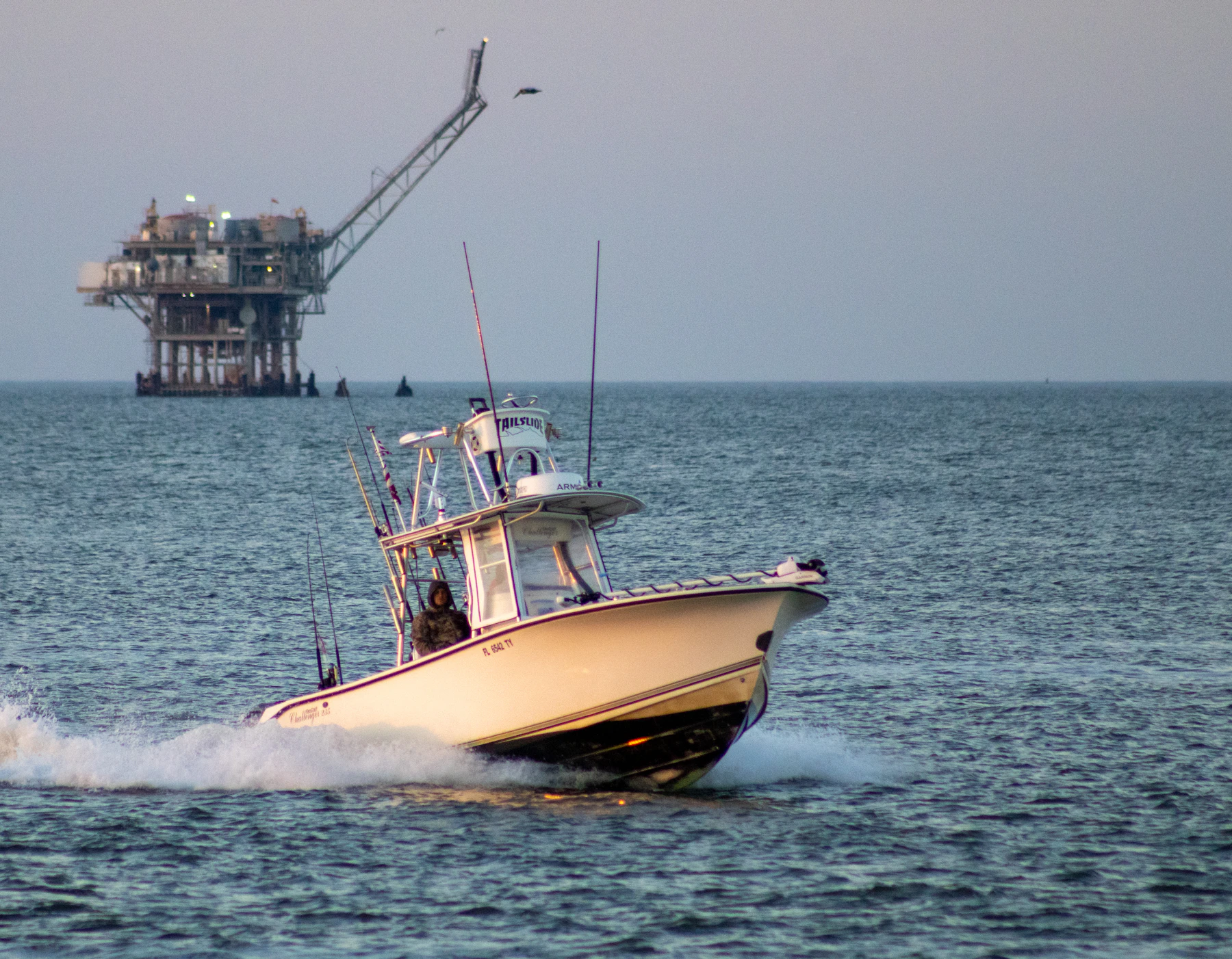 Boat sailing past an offshore oil rig