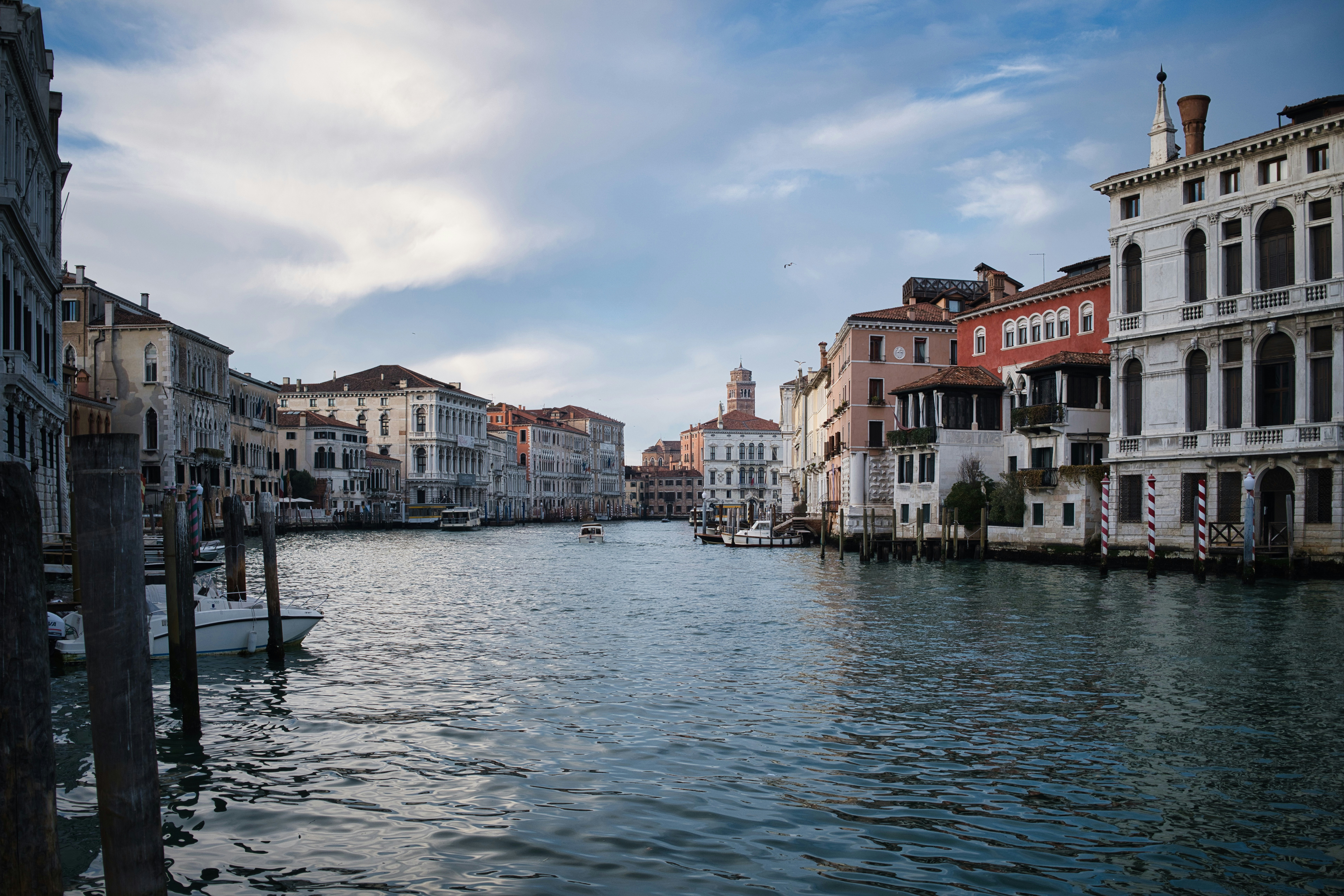 Canal with buildings in venice under cloudy sky