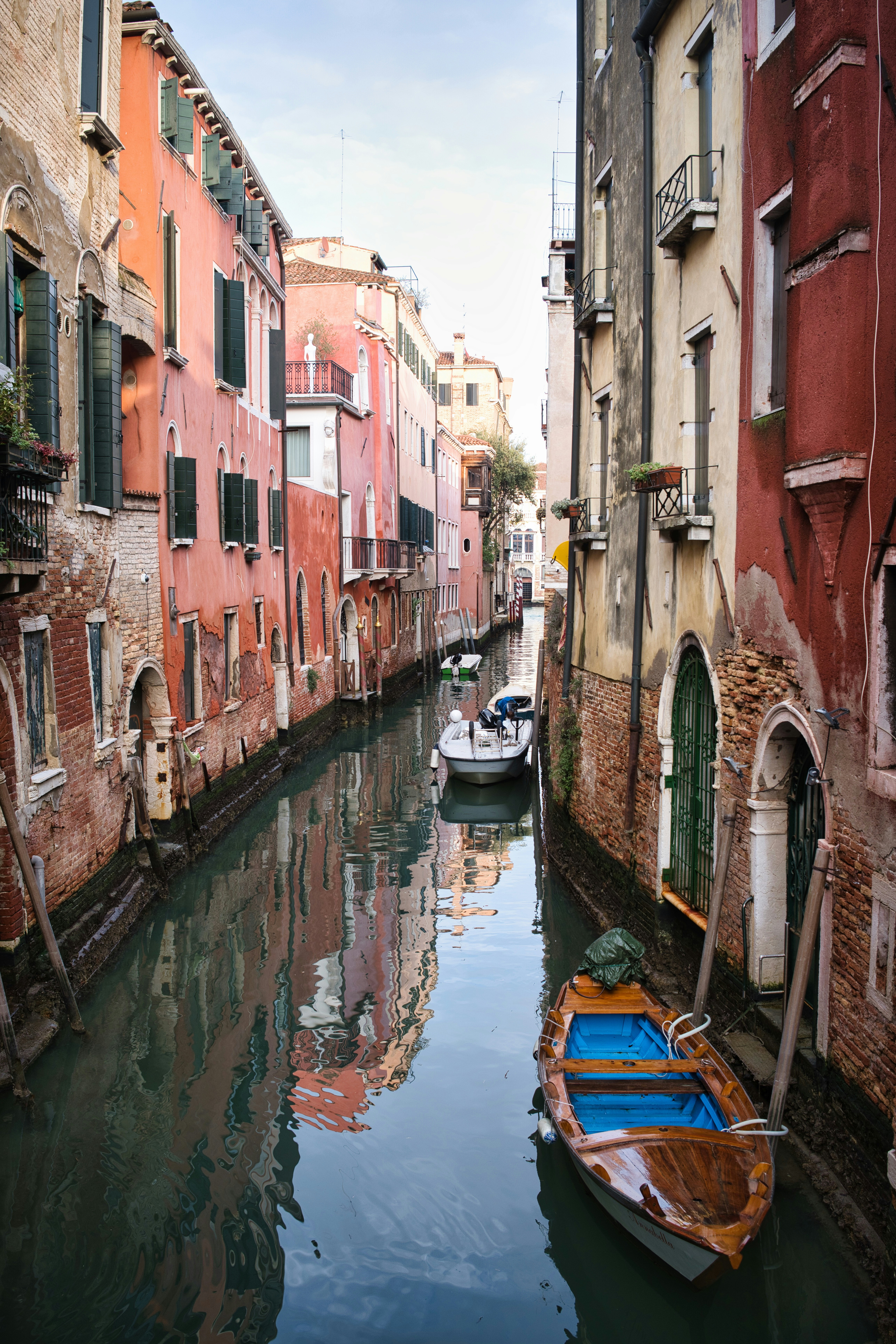 Narrow canal lined with colorful buildings in venice