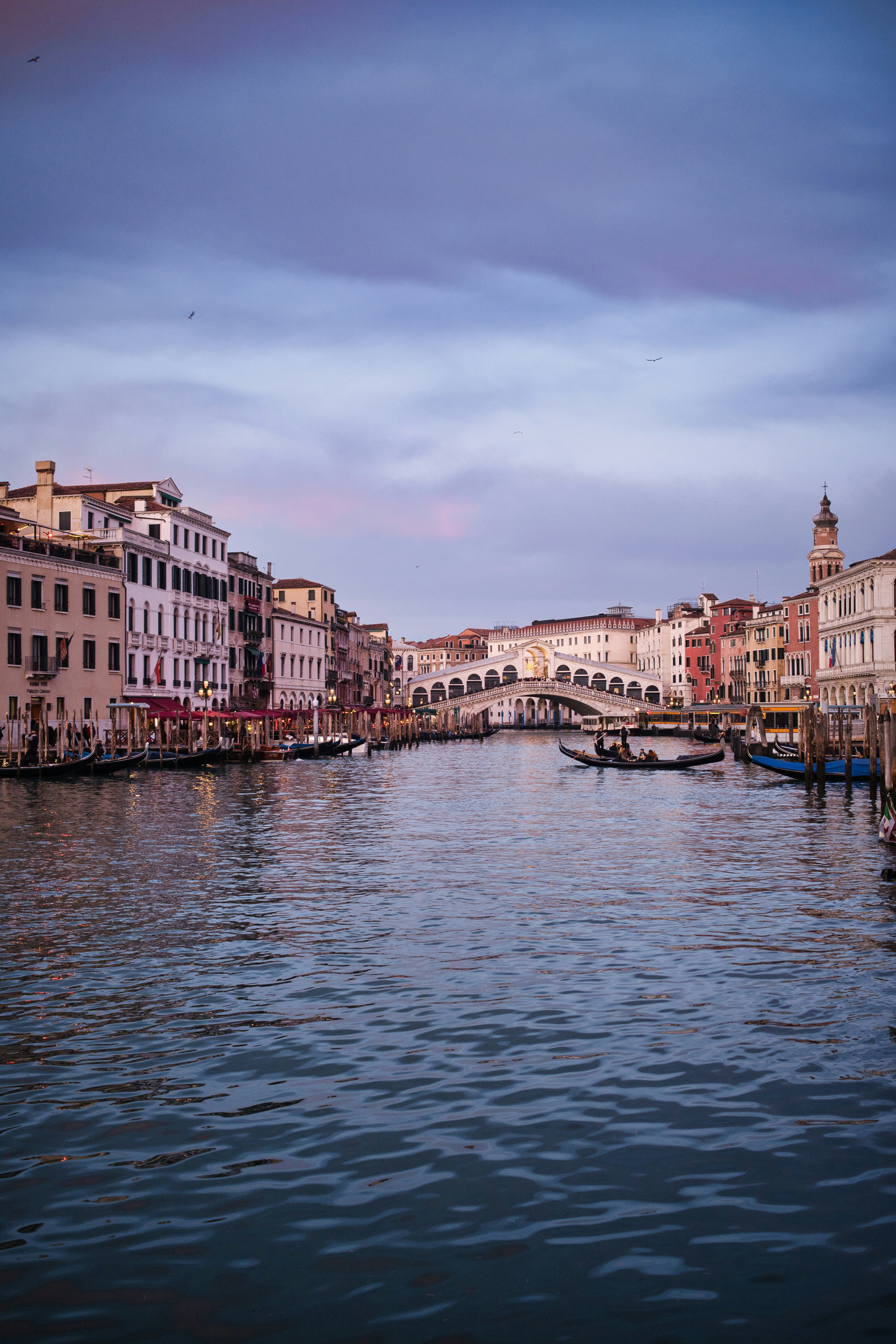 Gondolas on a canal in venice at sunset.