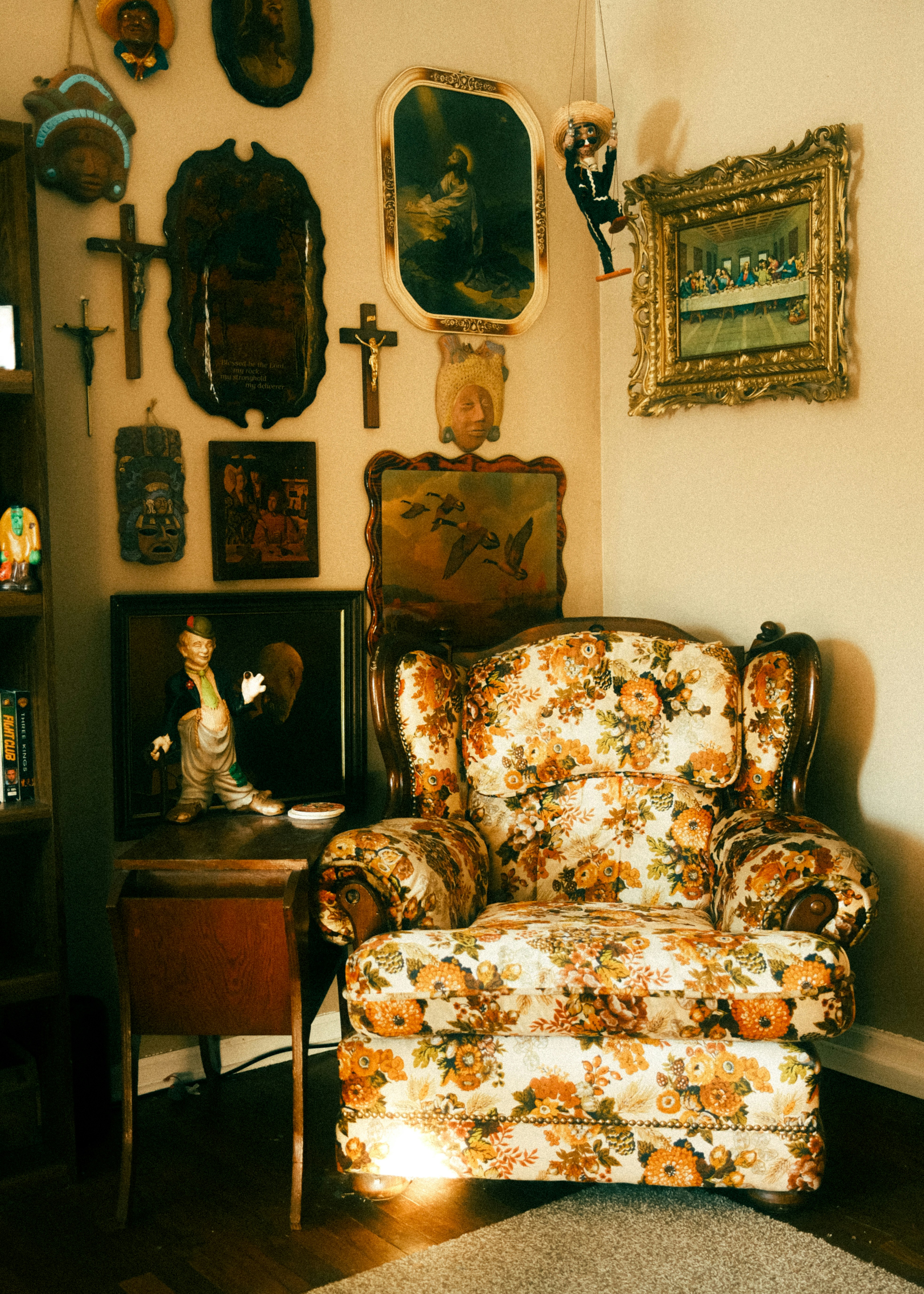 Floral armchair in a room with religious art.