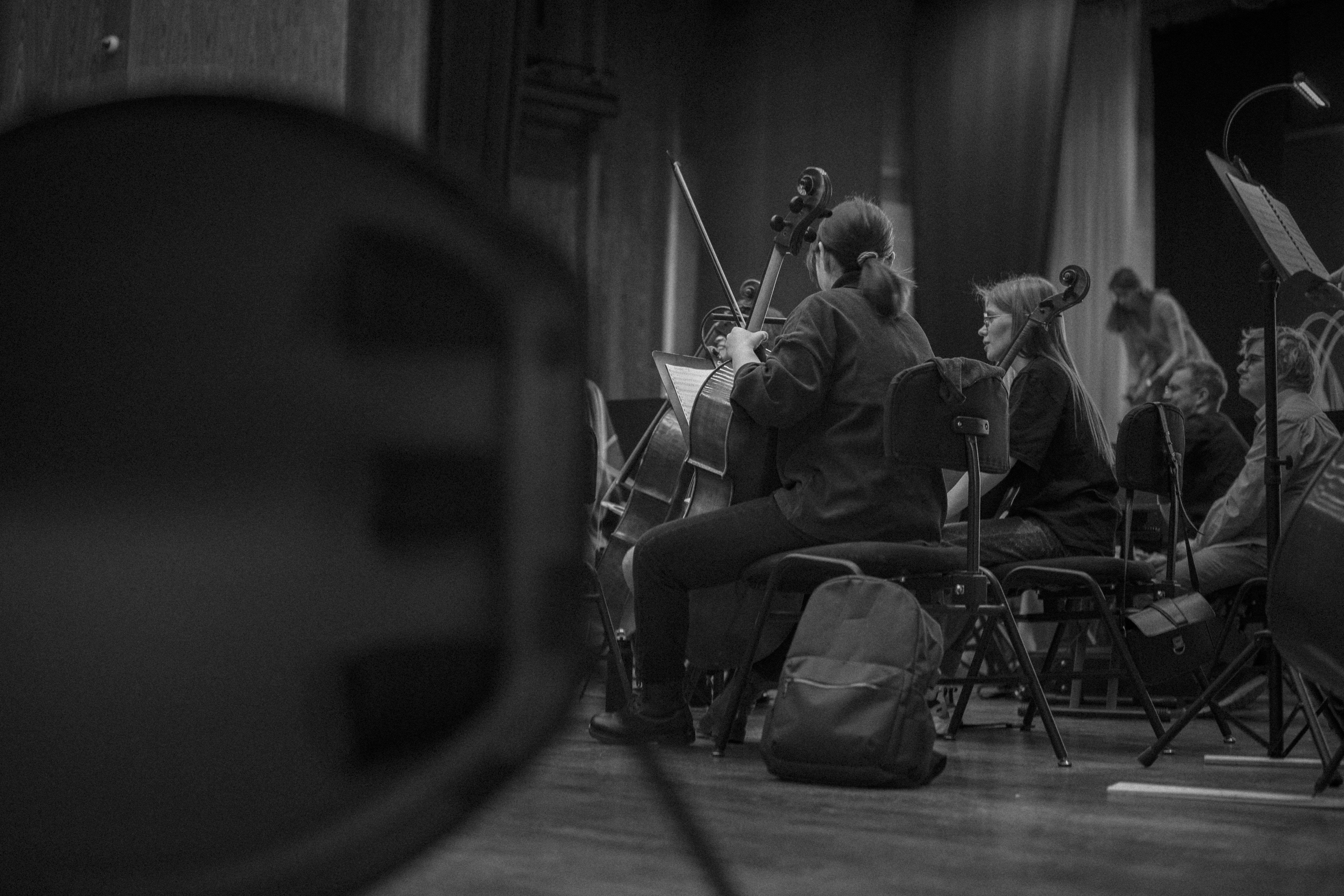 Musicians playing instruments on stage during rehearsal.