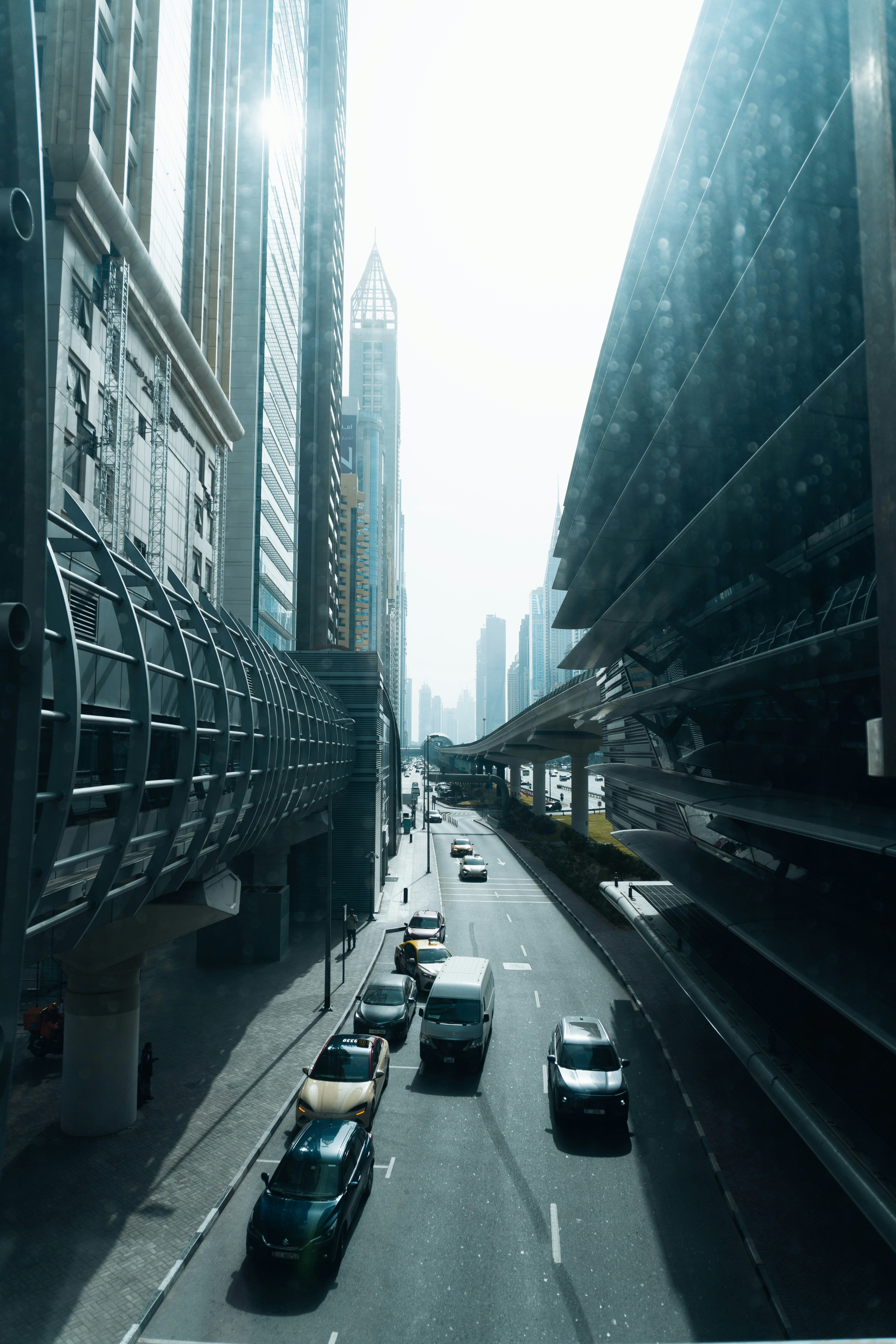 Veicoli che guidano su una strada cittadina trafficata con edifici alti.