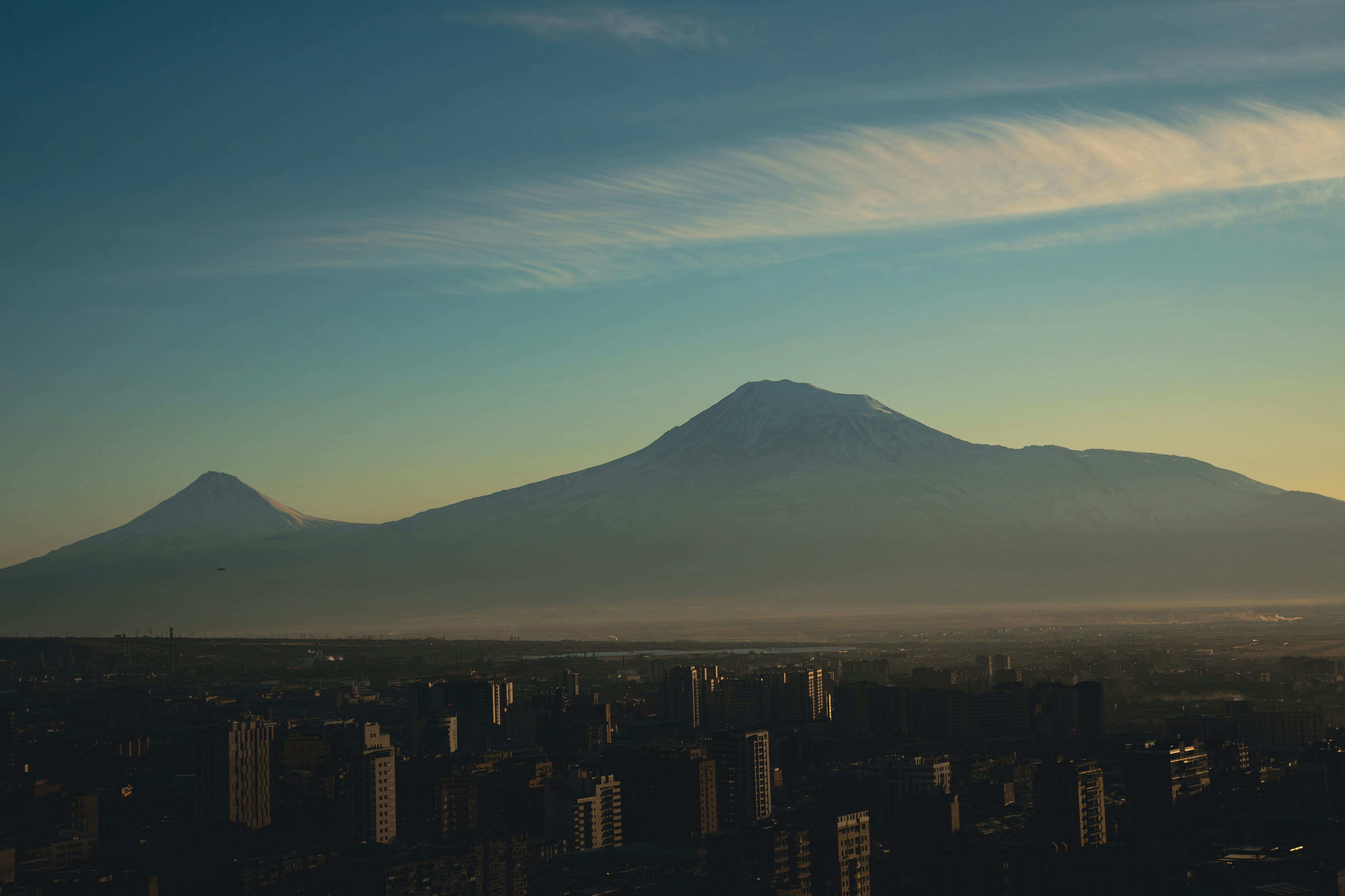 Majestic mountains rise above a city at dawn.