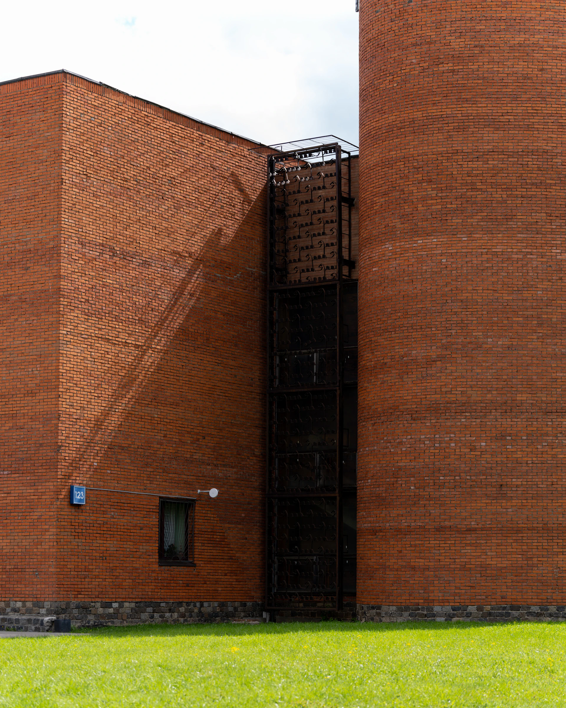 Modern brick building with metal fire escape and grass
