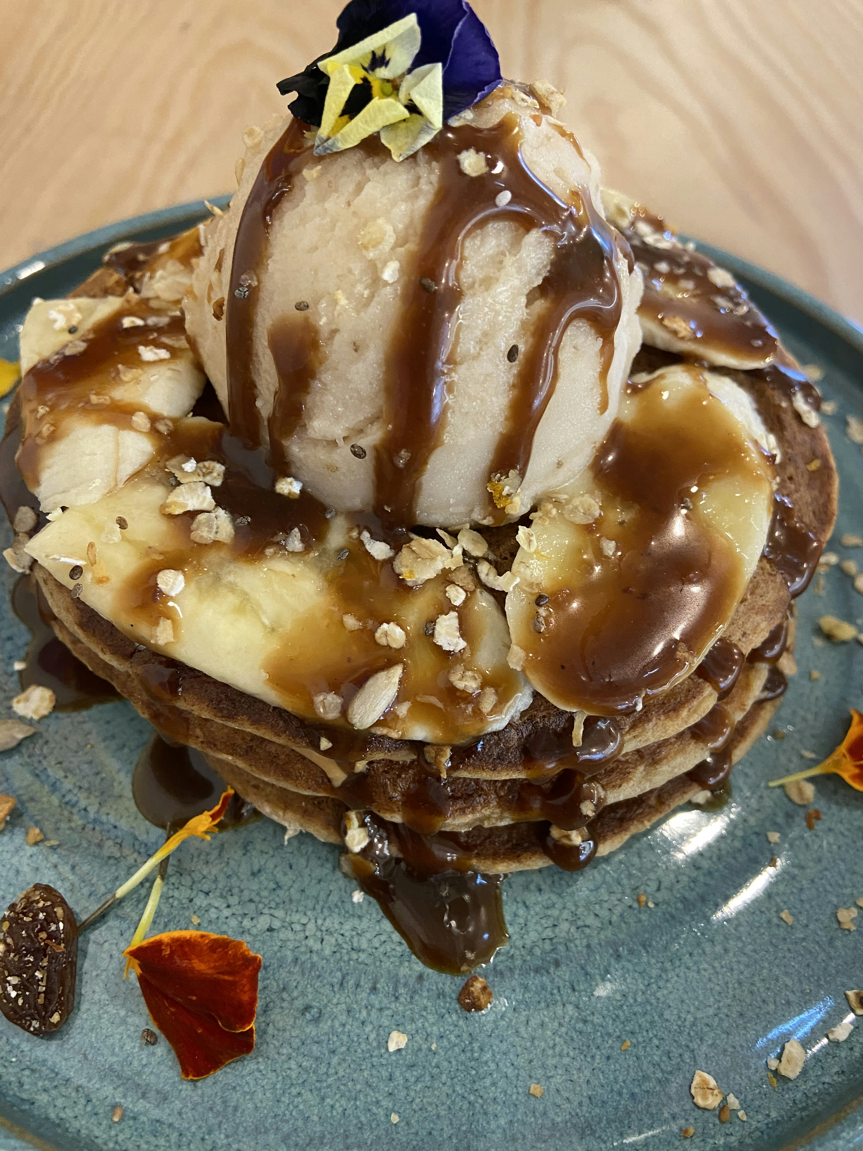 Stack of pancakes with ice cream, banana, and caramel sauce.