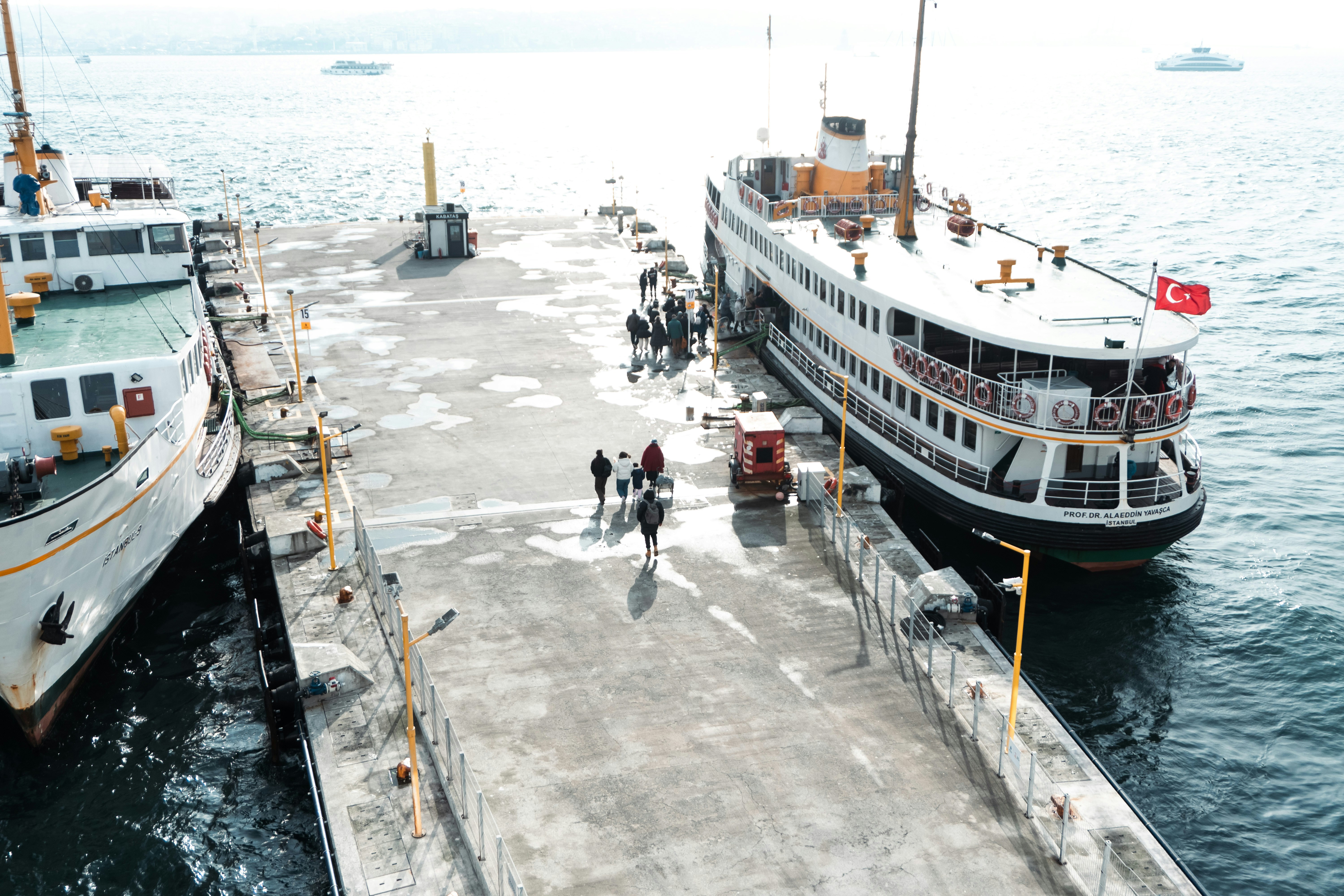 Ferries docked at a pier with people walking