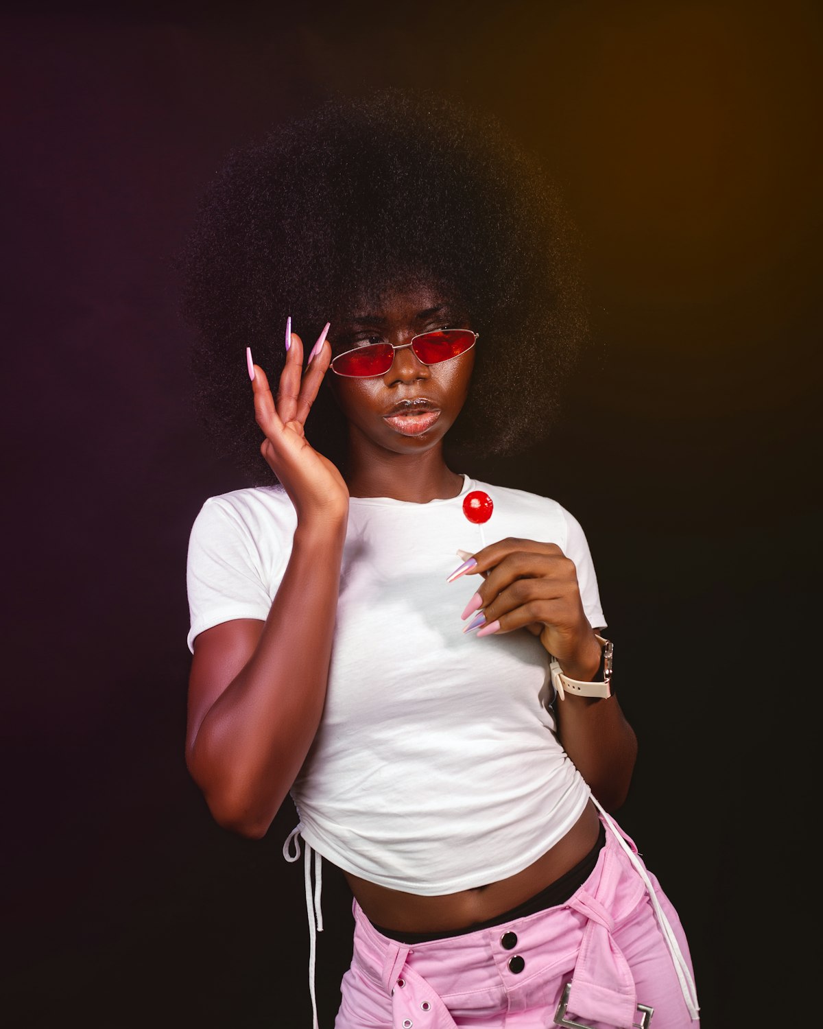 A woman in red sunglasses holding a lollipop