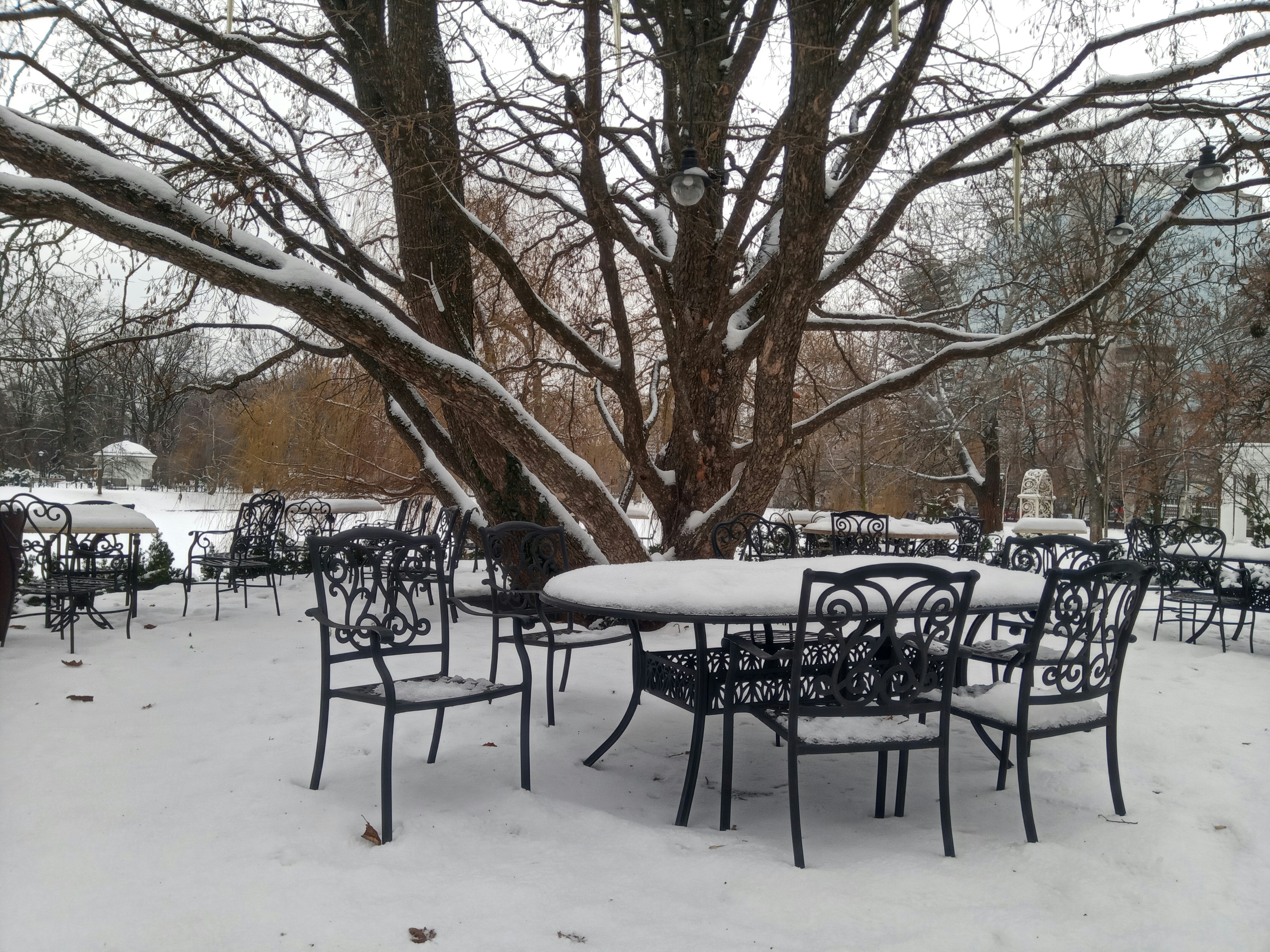 Outdoor cafe tables and chairs covered in snow