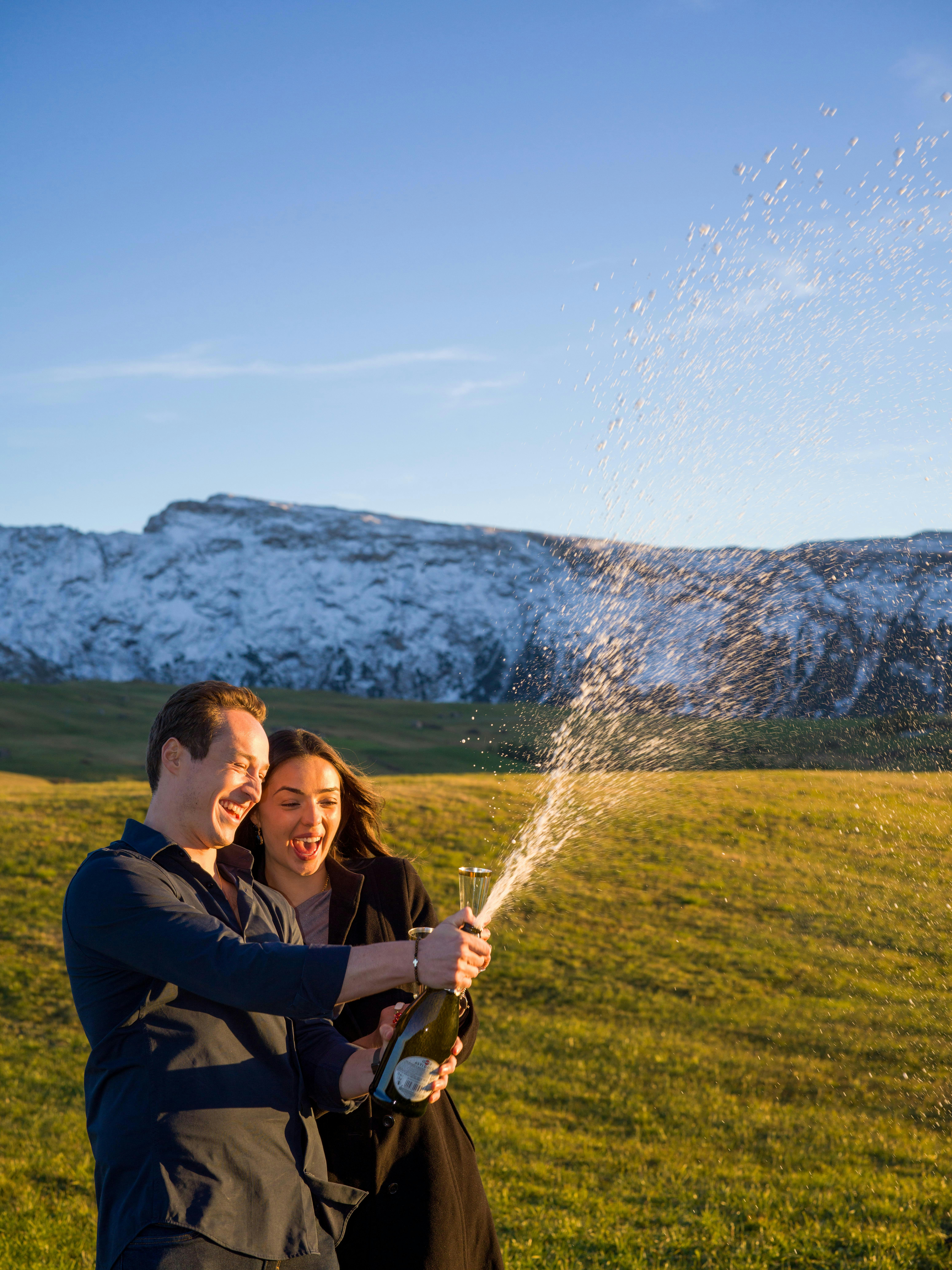 Couple fêtant avec du champagne en plein air