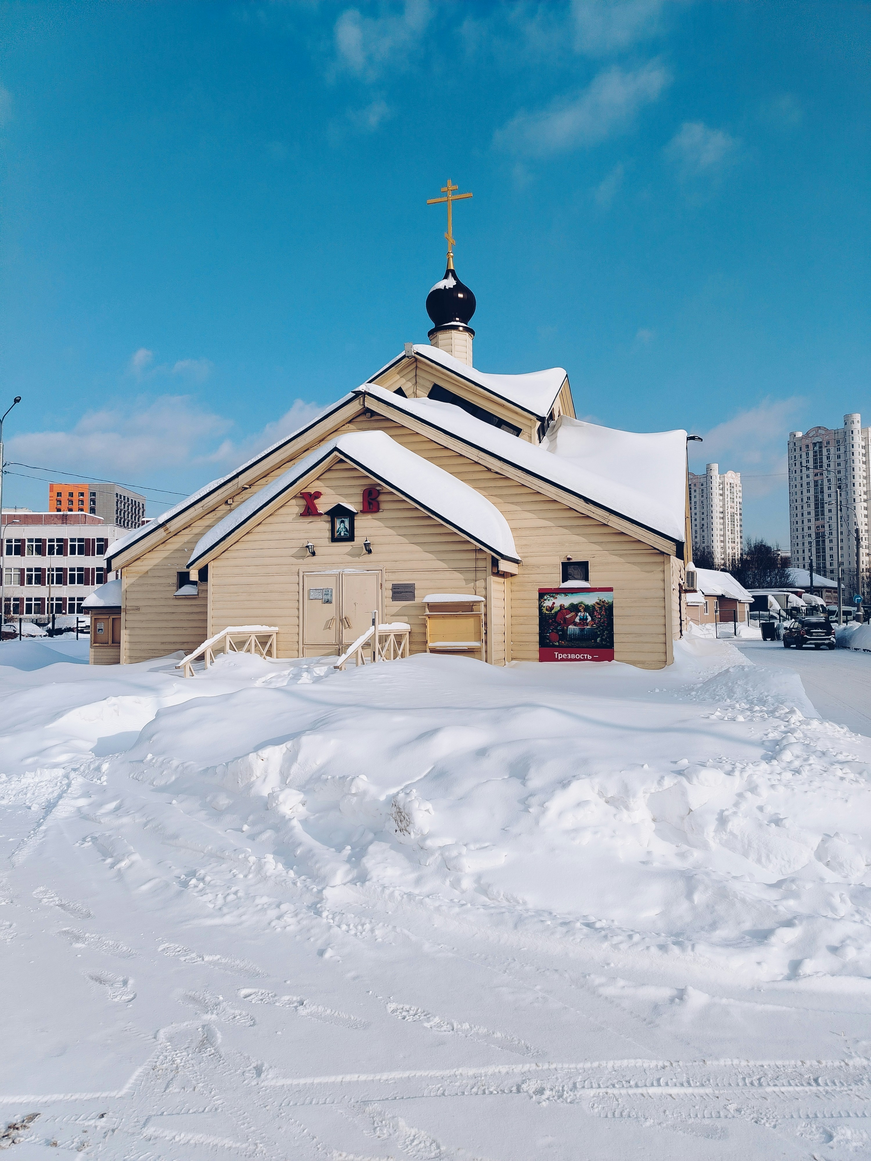 青空の下、雪に覆われた木造の教会
