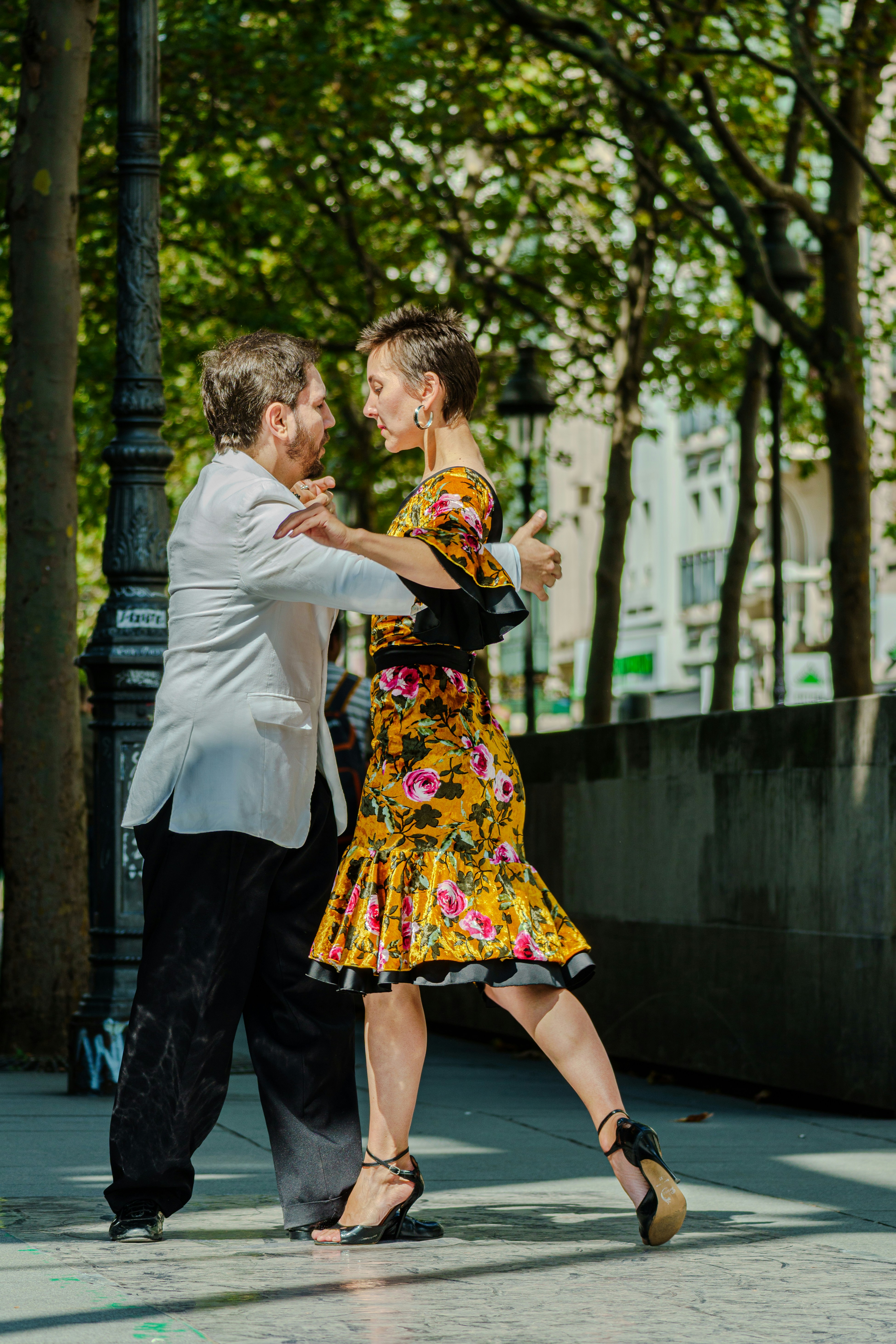 화창한 날 야외에서 탱고를 추는 몇 명.