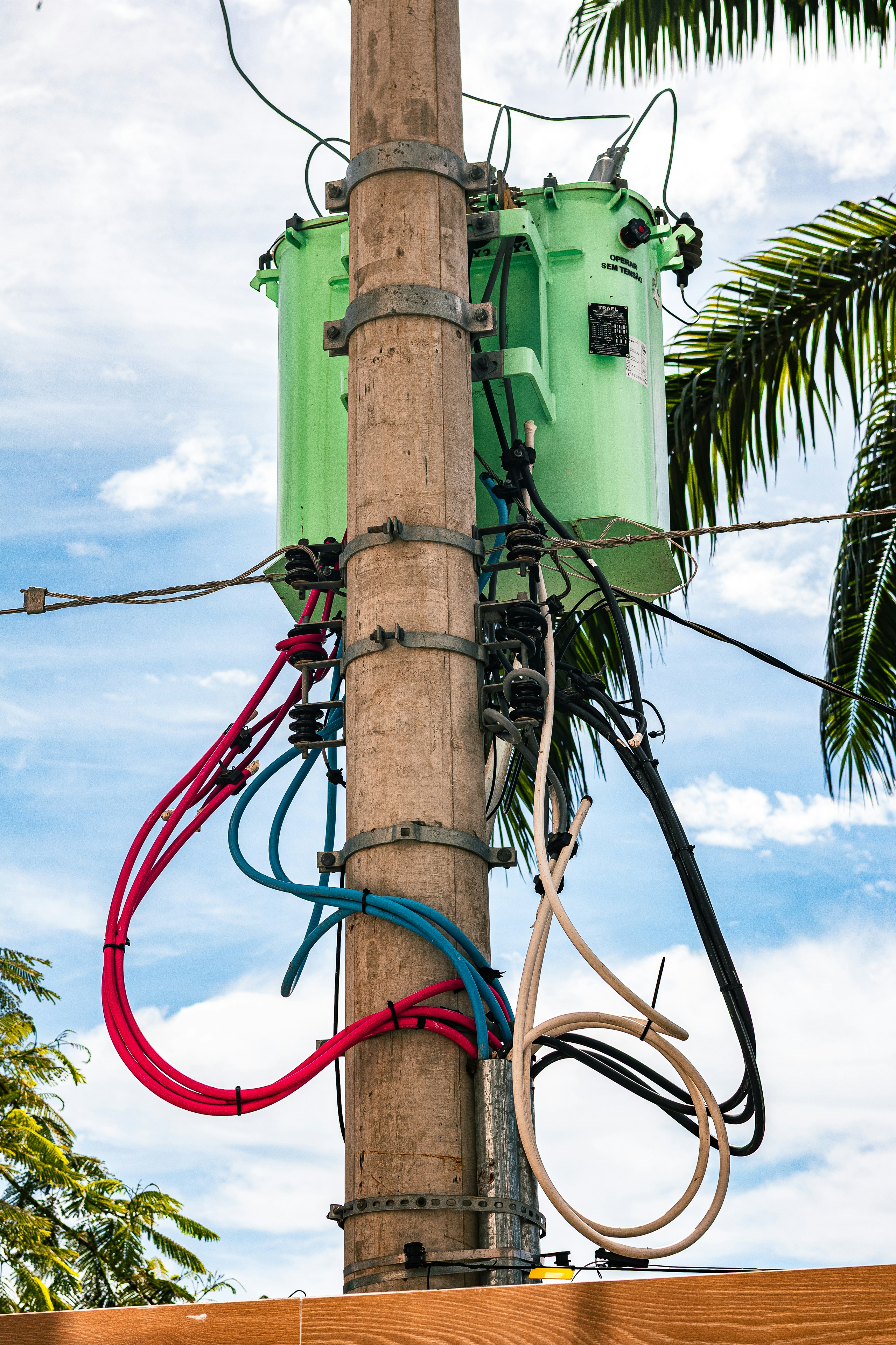 A green electrical transformer mounted on a utility pole.
