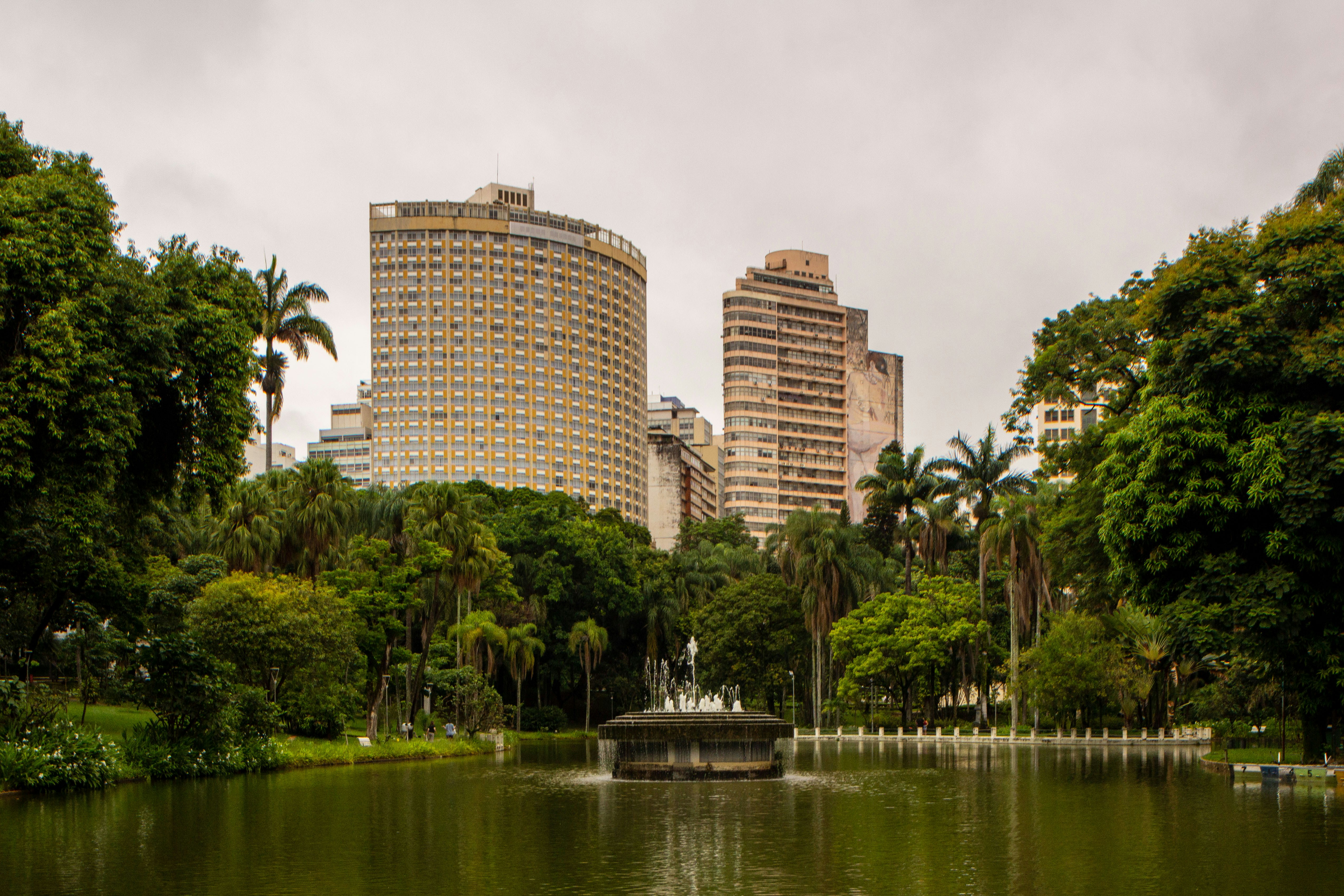 City skyline behind a tranquil park with a pond.