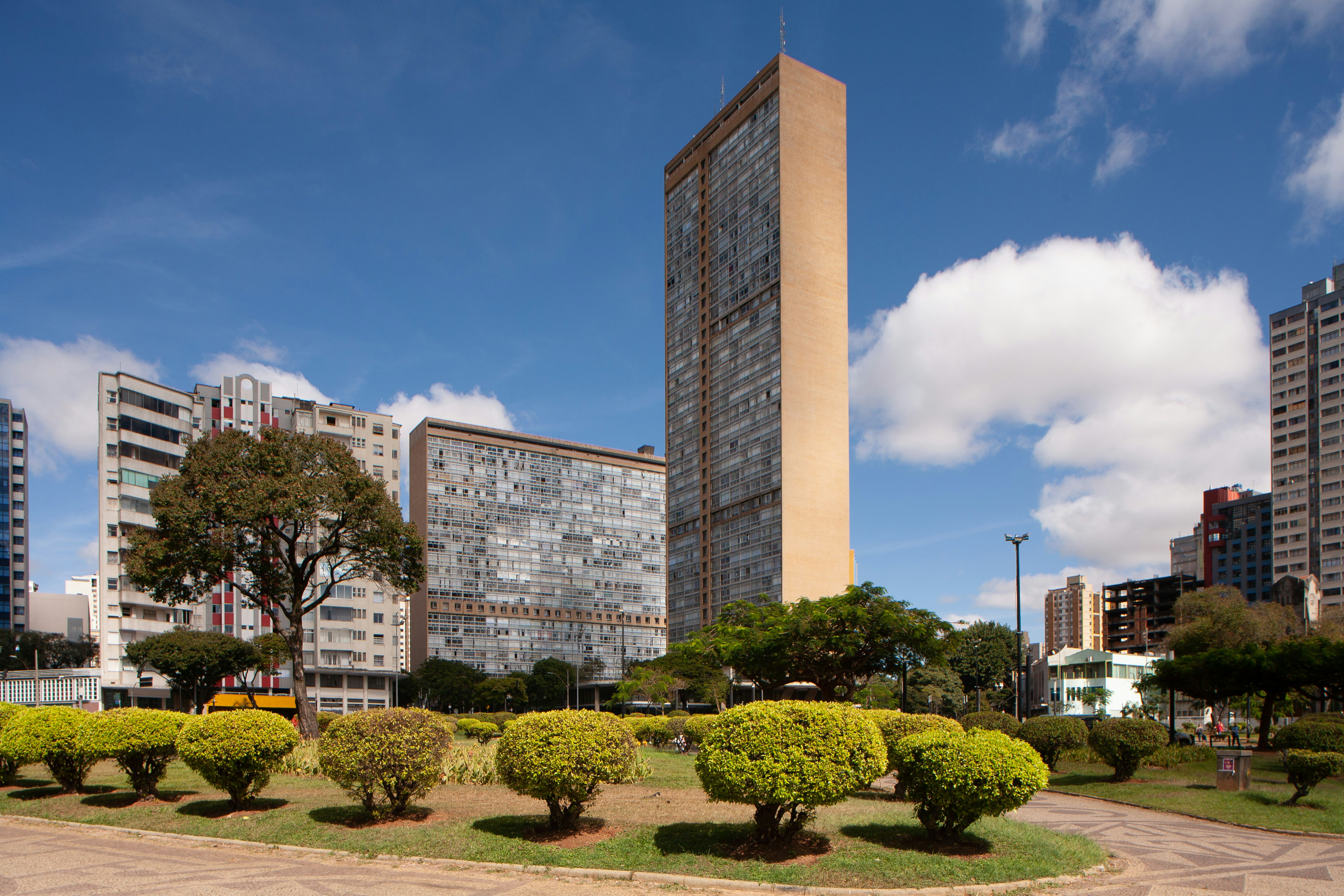 Modern buildings and manicured park under a blue sky